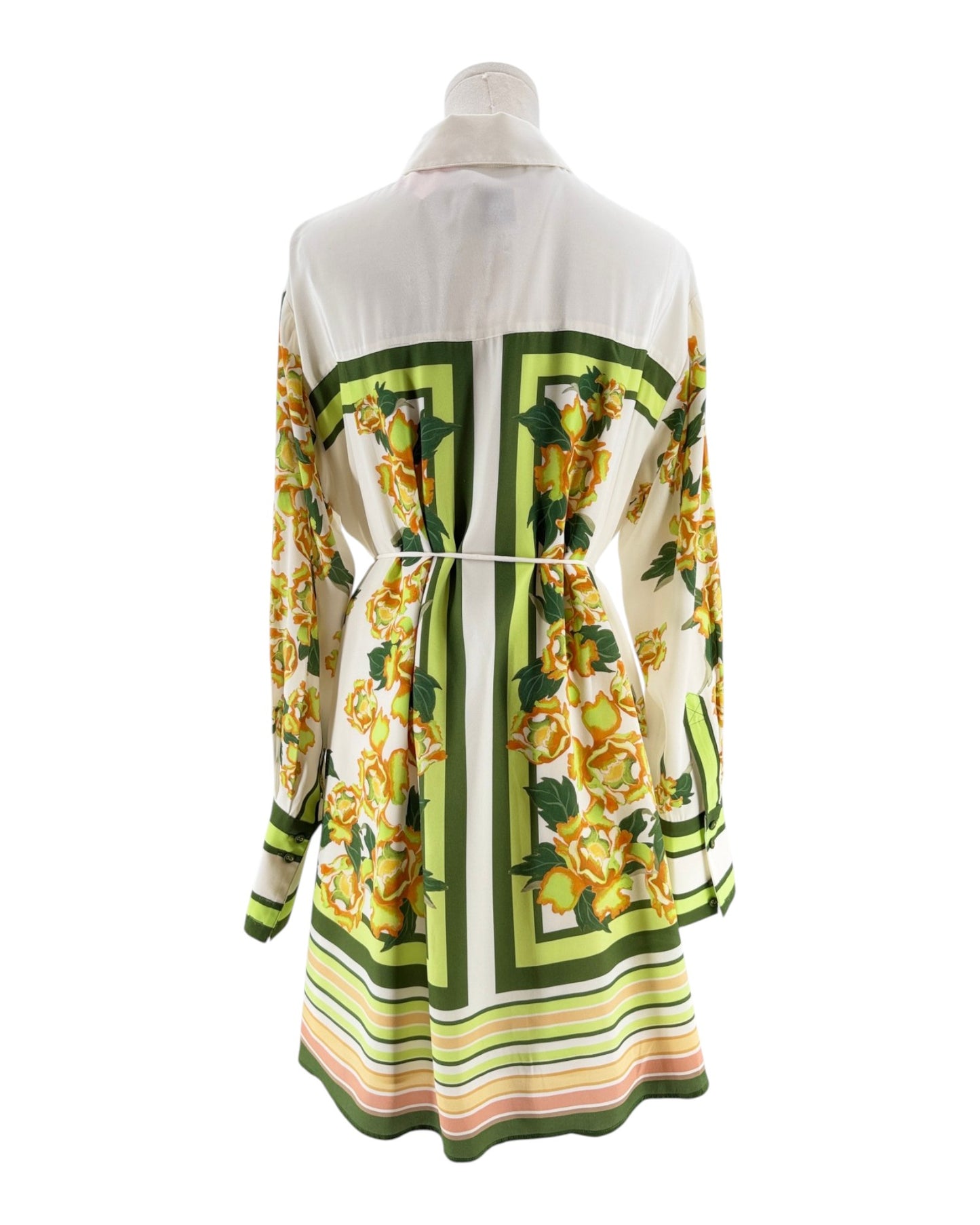 Mannequin wearing a patterned dress with green, yellow, and white design on a white background