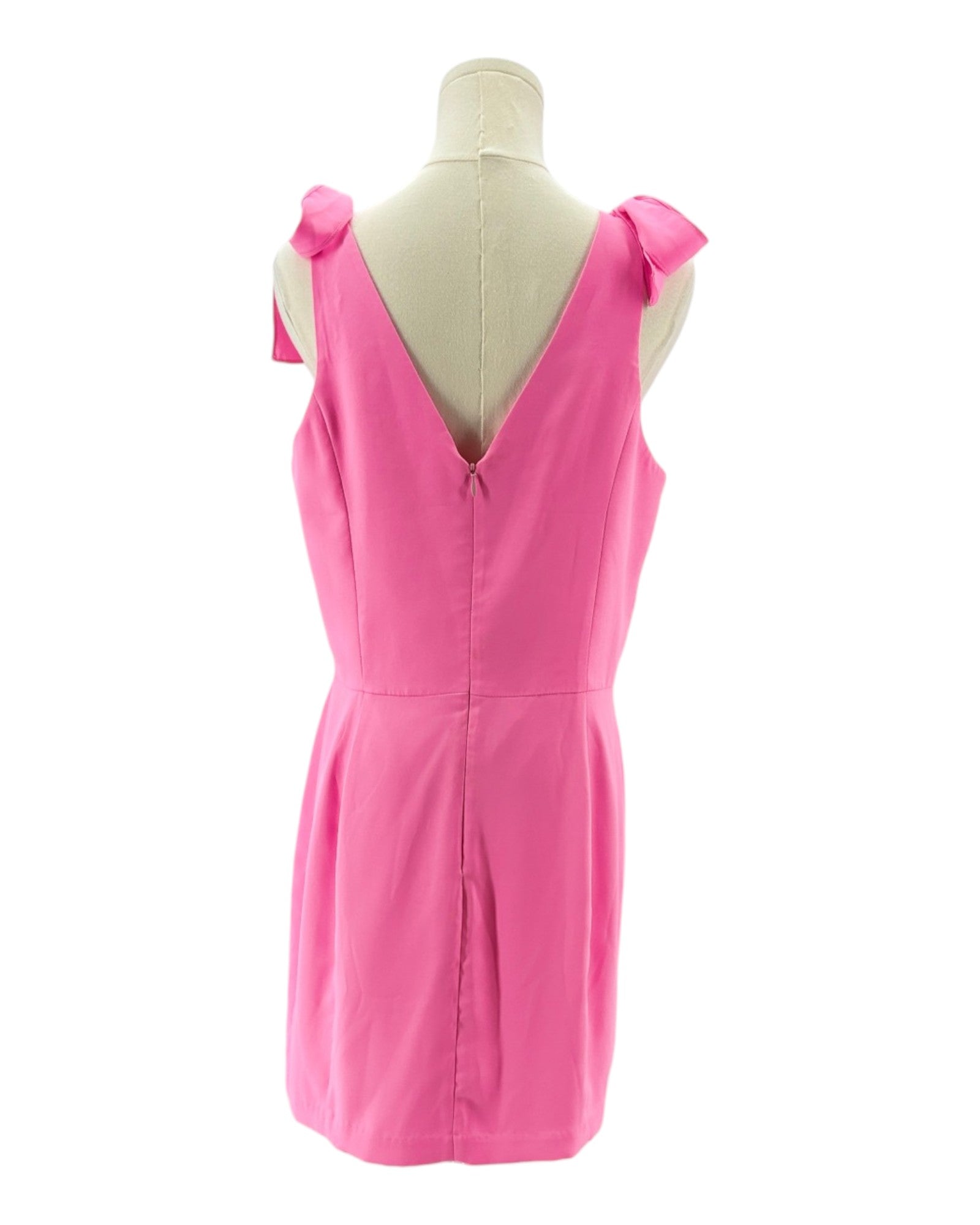 Amanda Uprichard pink dress on a mannequin with bow details against a white background