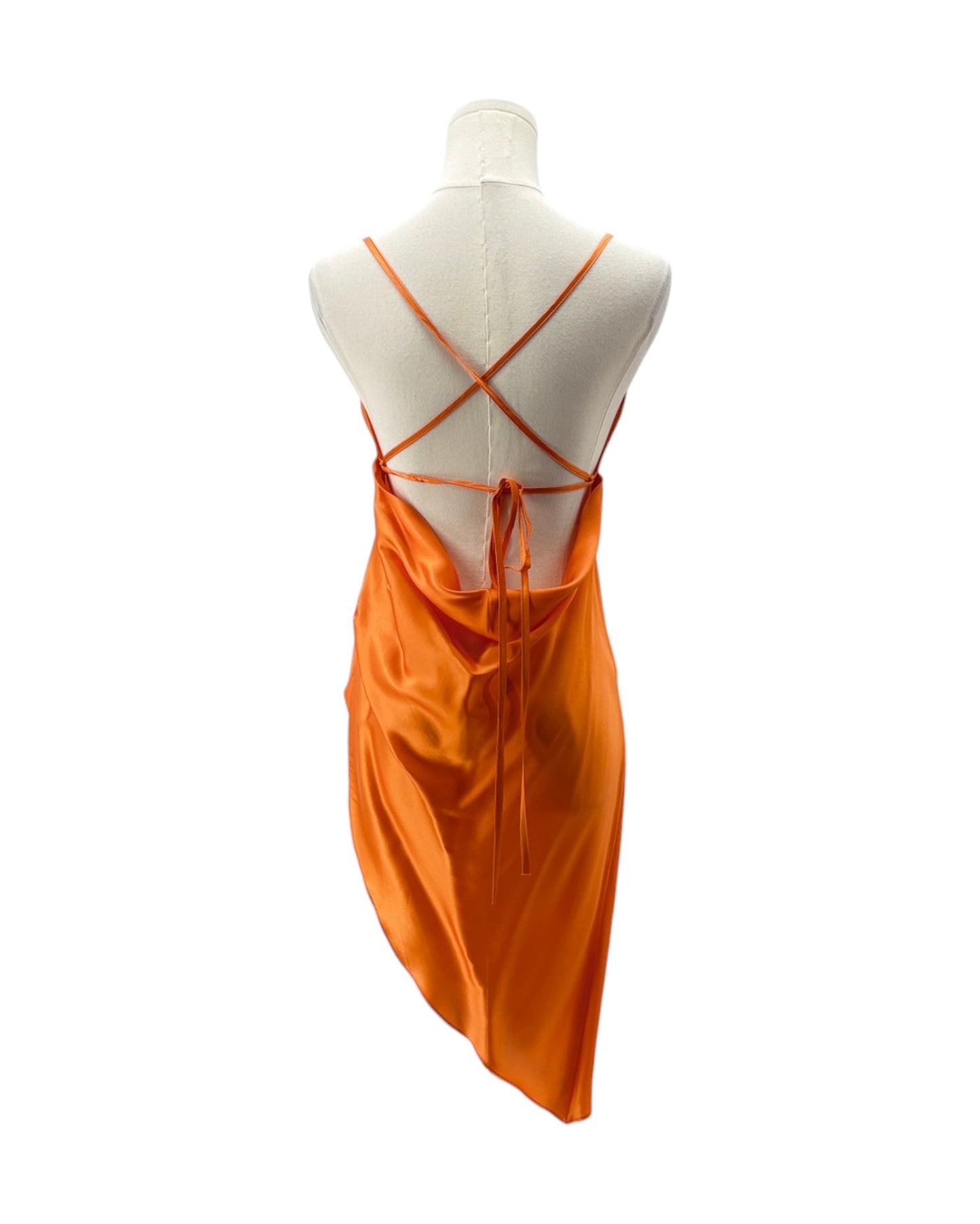 Orange dress on a mannequin with criss-cross straps against a white background