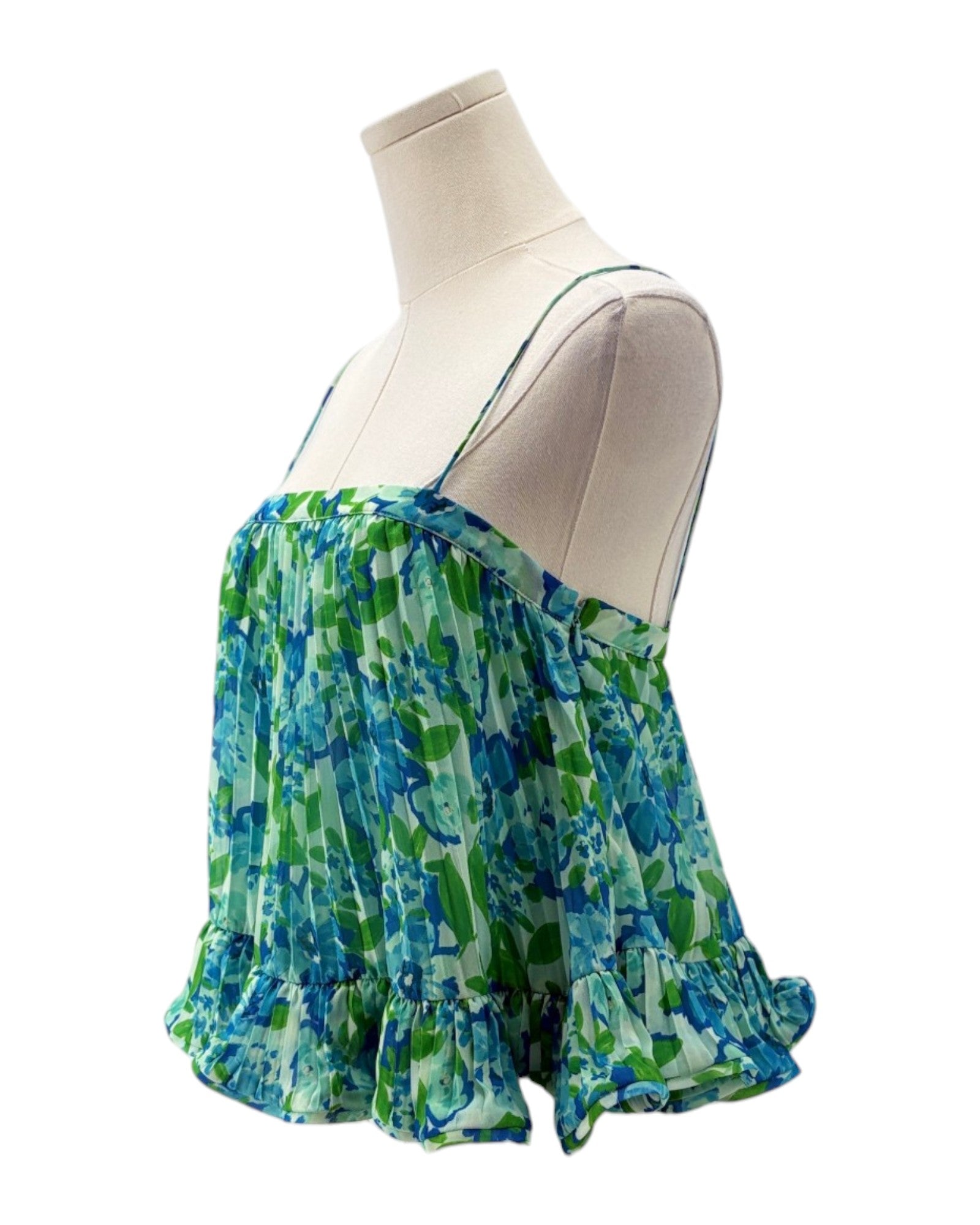 Green and blue patterned top on a mannequin against a white background