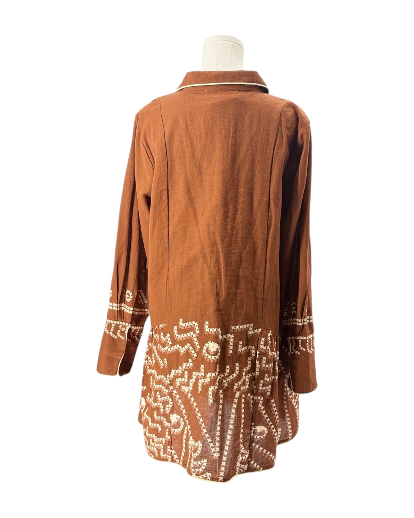 Brown dress with intricate white patterns on a mannequin against a white background