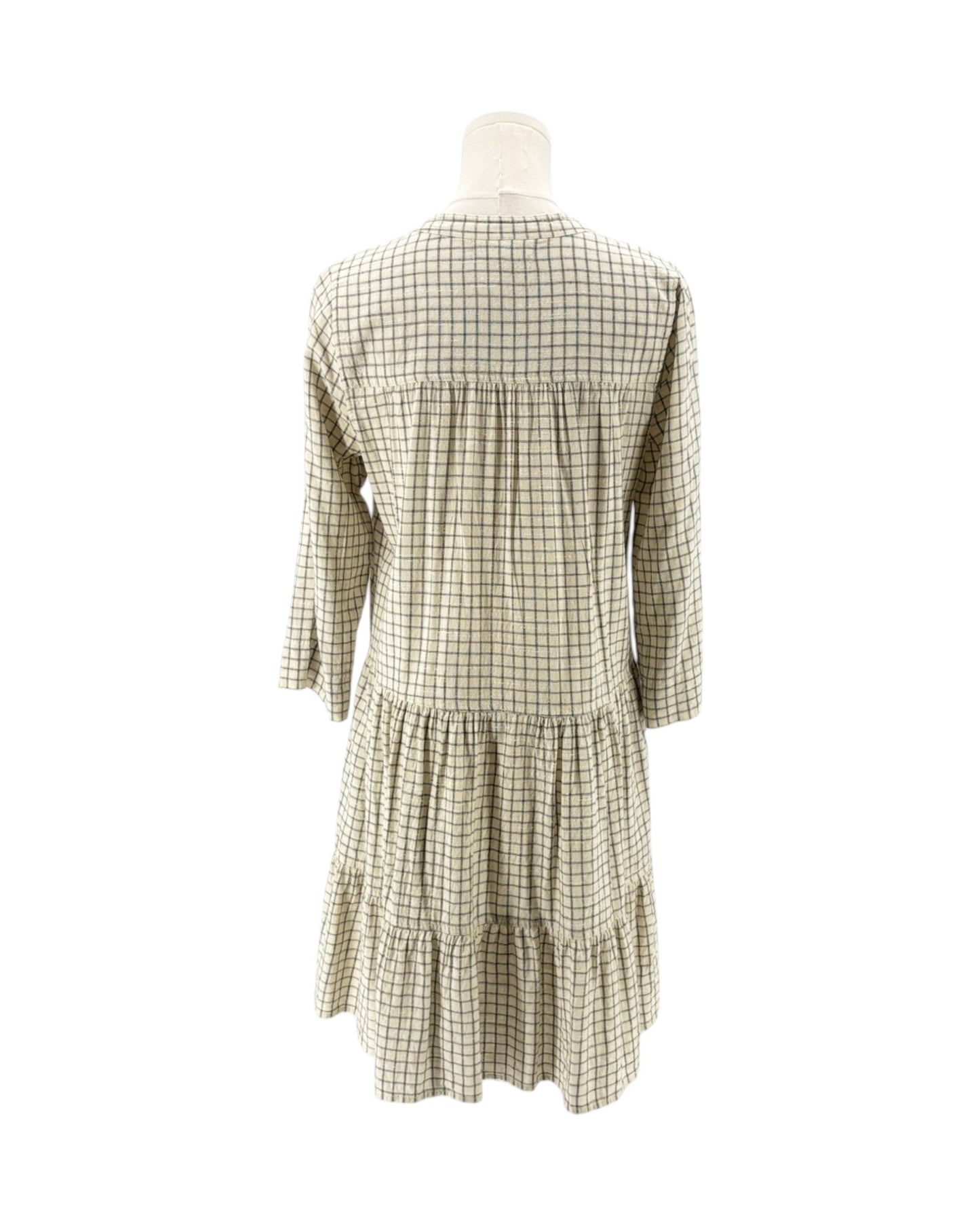 Green and white checkered dress on a mannequin against a white background