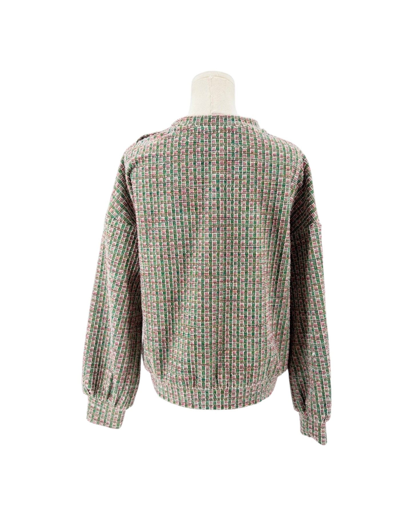 A long-sleeve knit sweater with a dense multicolor grid pattern of green, pink, and beige, displayed on a mannequin from the back against a white background.