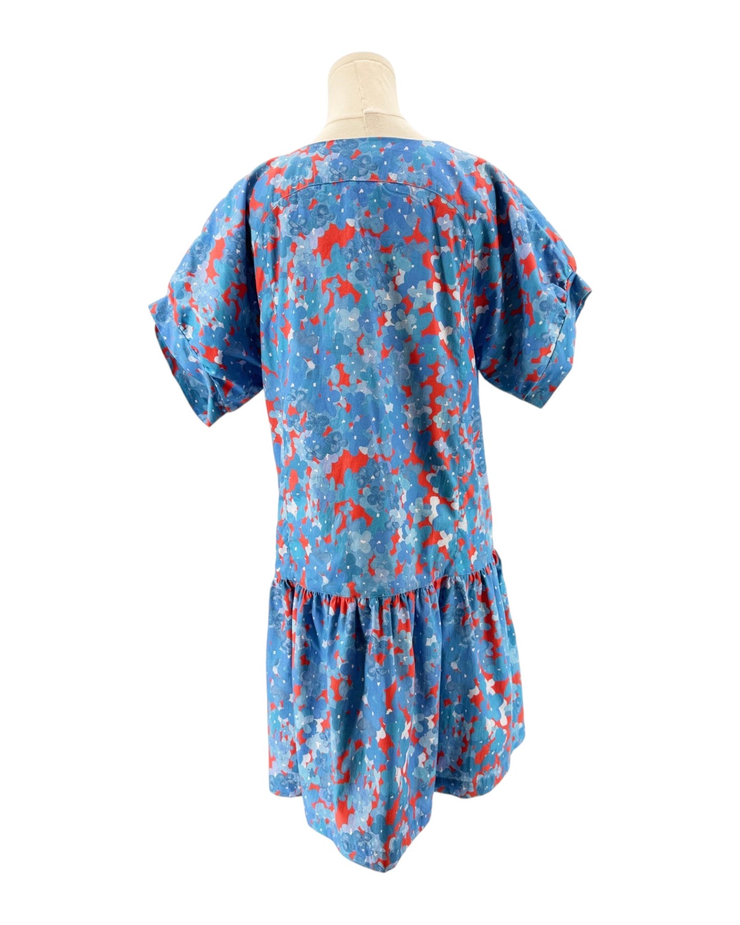 Blue dress with red floral pattern on a mannequin against a white background