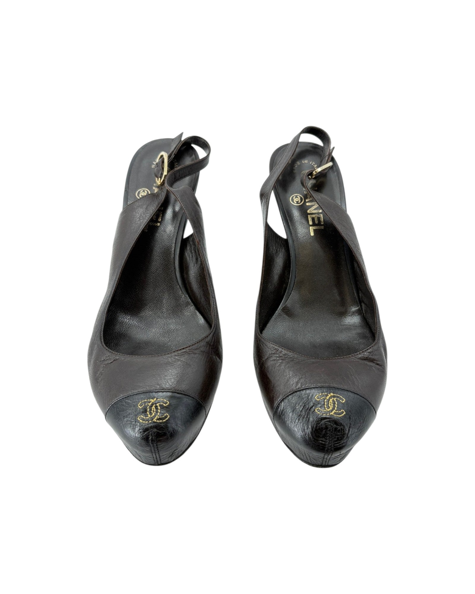 Pair of black leather shoes with Chanel logo on a white background