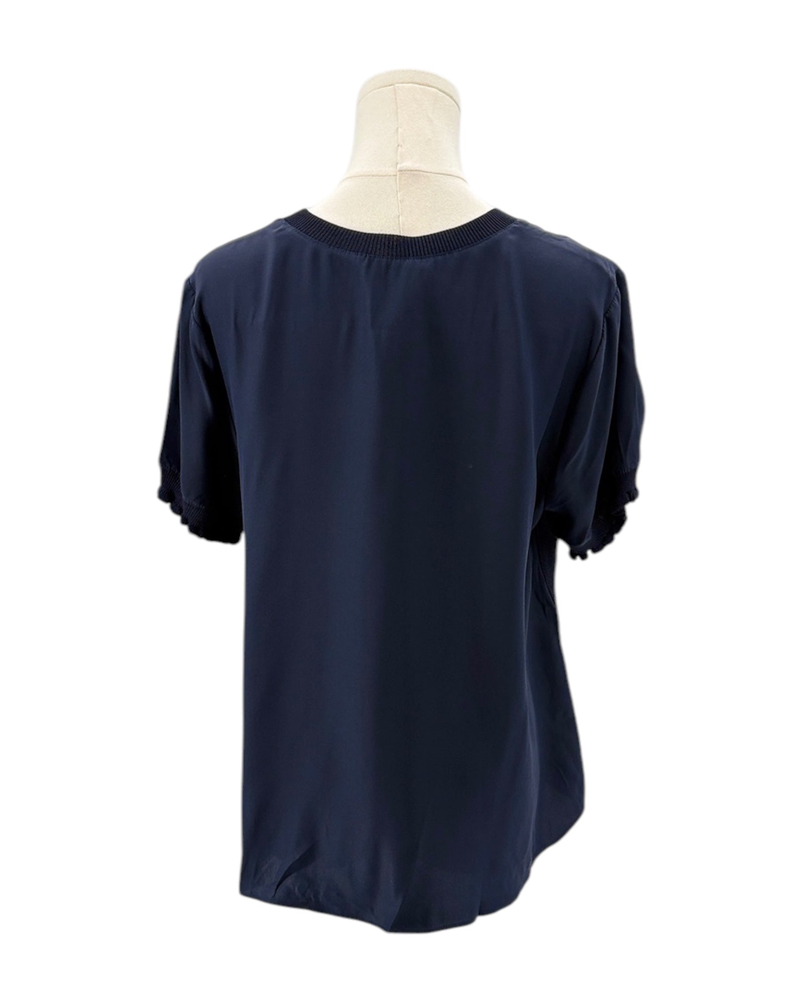 Cinq a Sept navy blue silk shirt on a mannequin against a white background