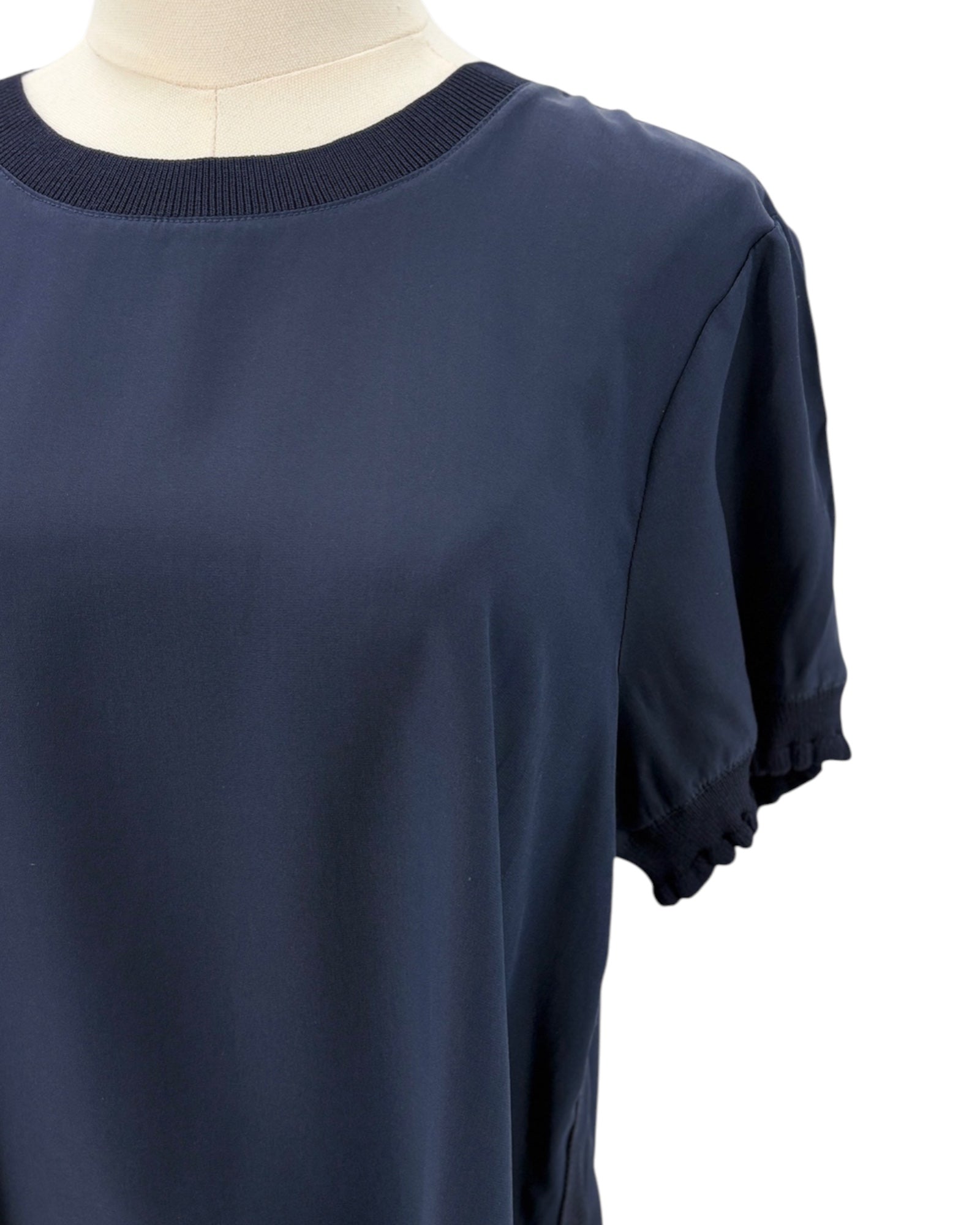 Cinq a Sept navy blue silk shirt on a mannequin against a white background