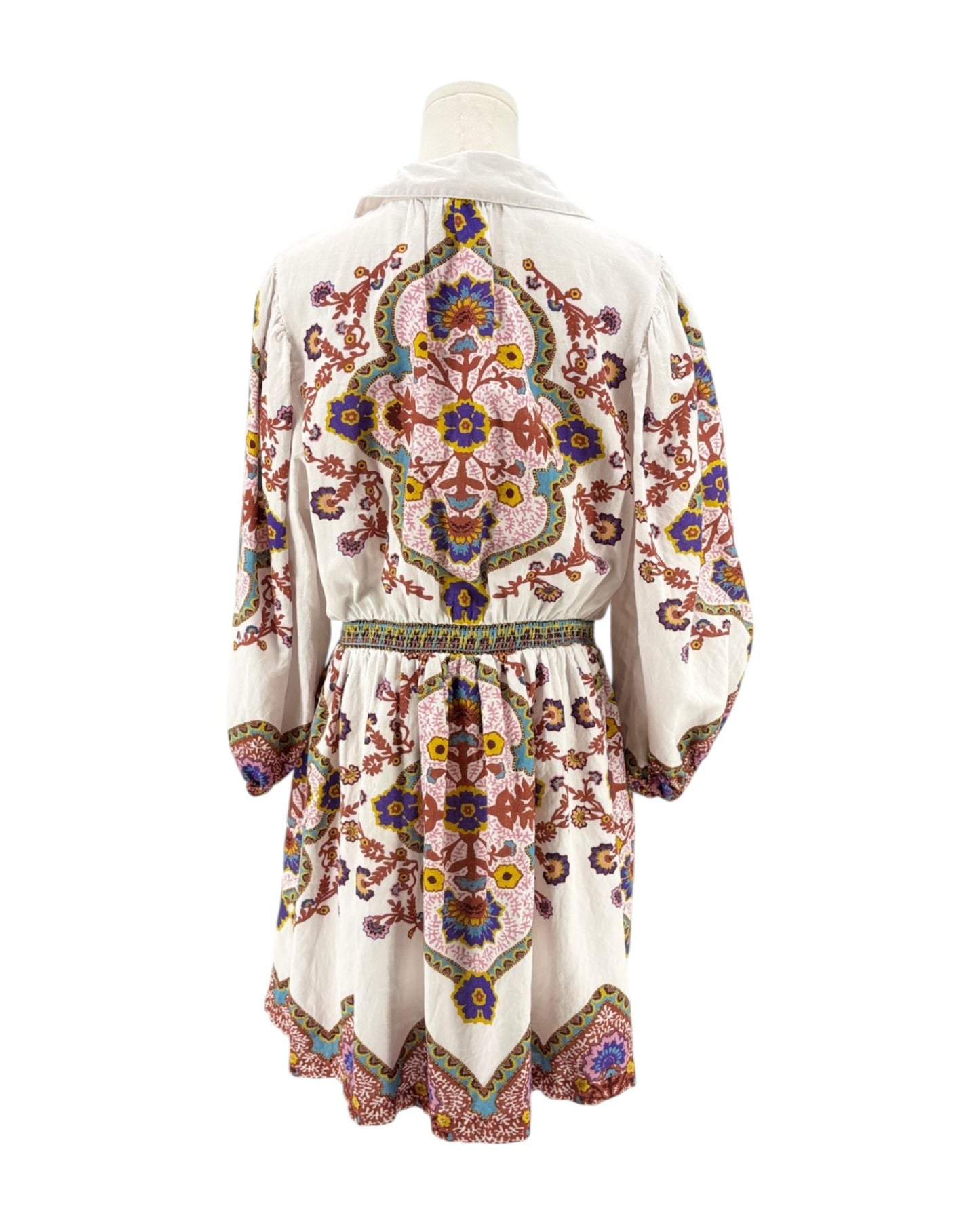 Colorful embroidered dress on a mannequin against a white background