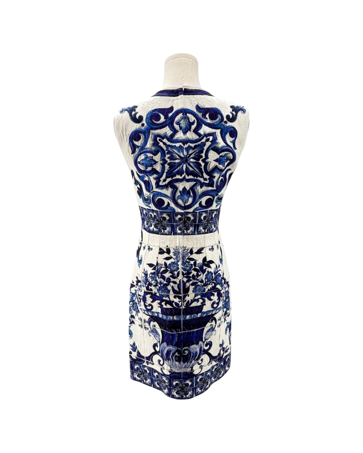 A sleeveless white dress with an intricate blue and black baroque-style pattern, shown from the back on a mannequin against a white background.