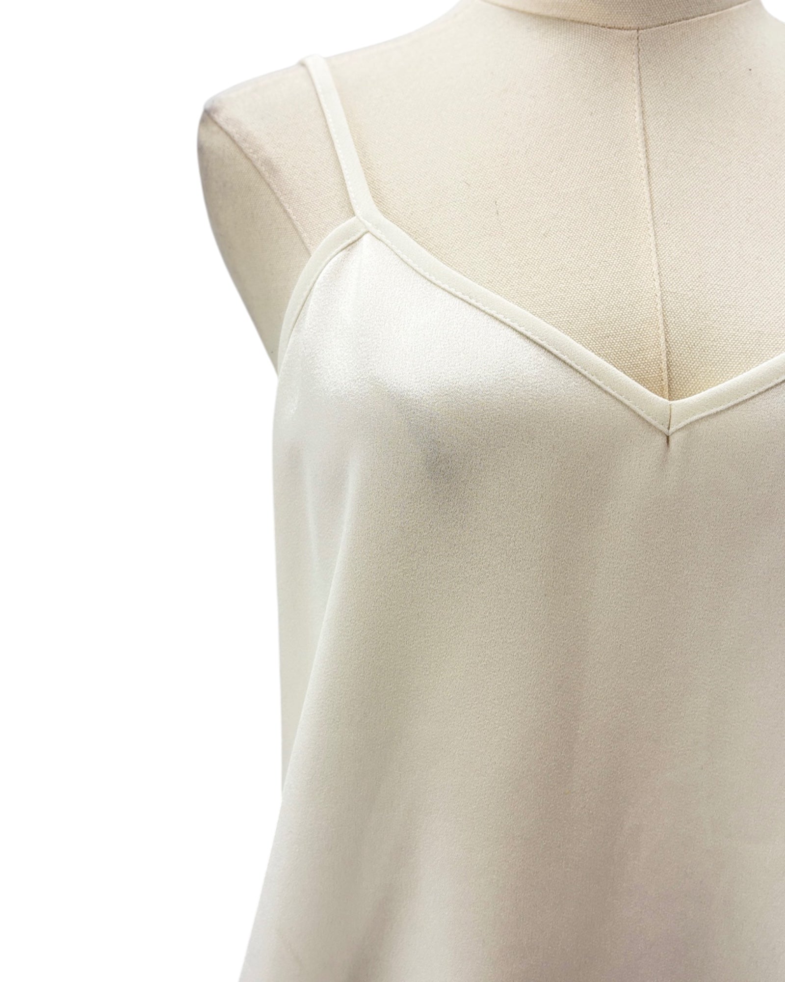 White sleeveless top on a mannequin with a white background