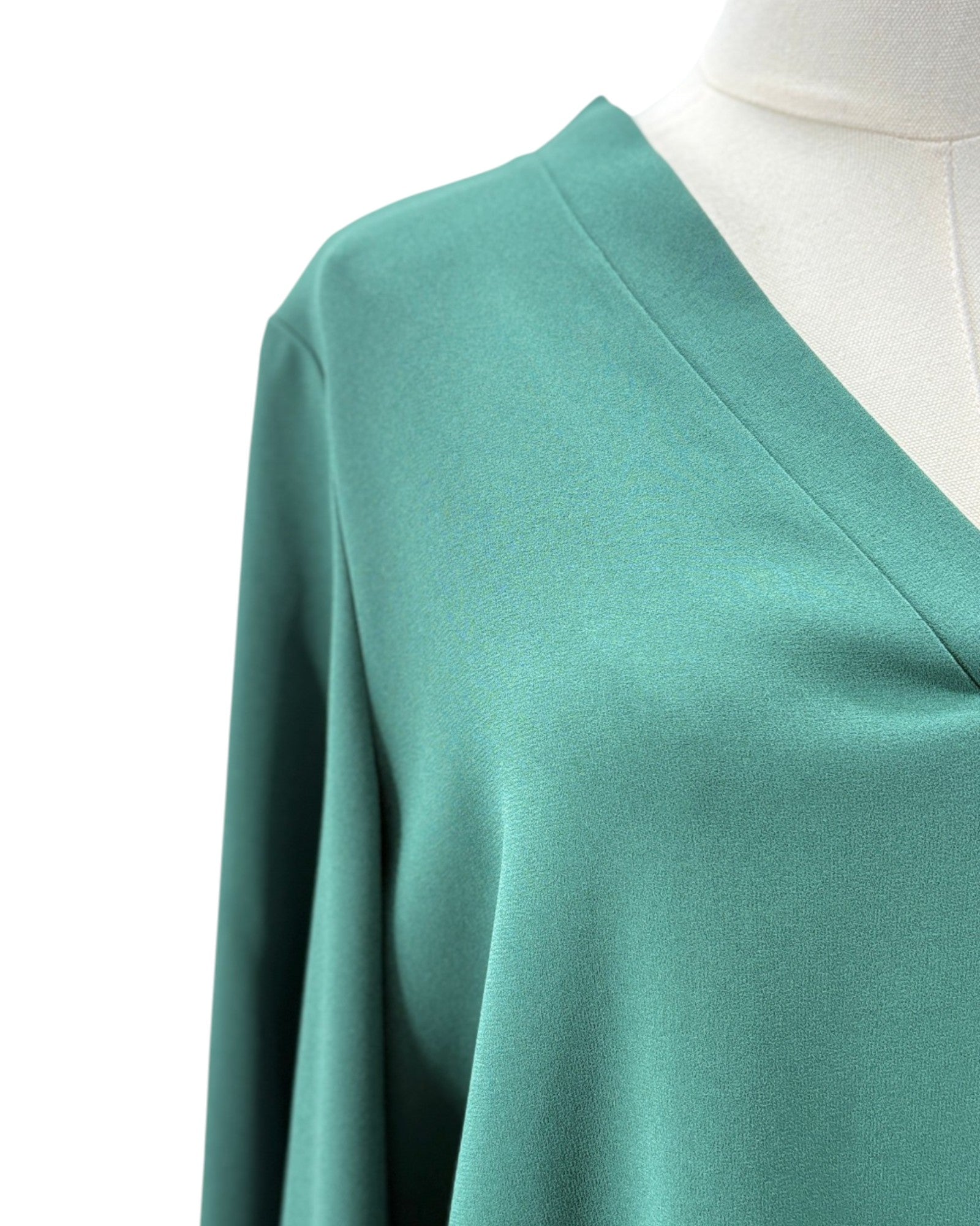 Teal long-sleeve top on a mannequin with a white background