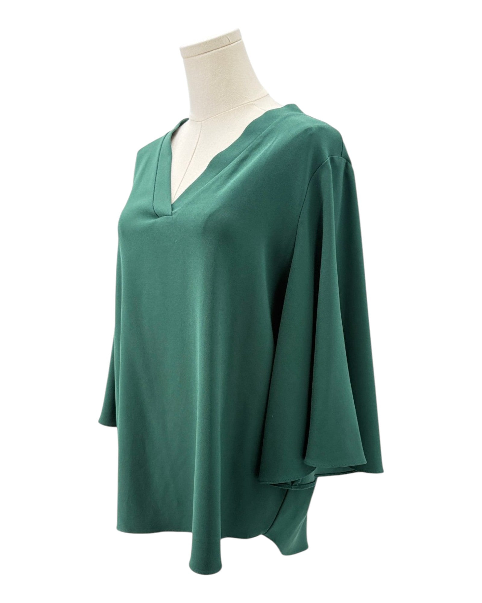 Green blouse on a mannequin against a white background