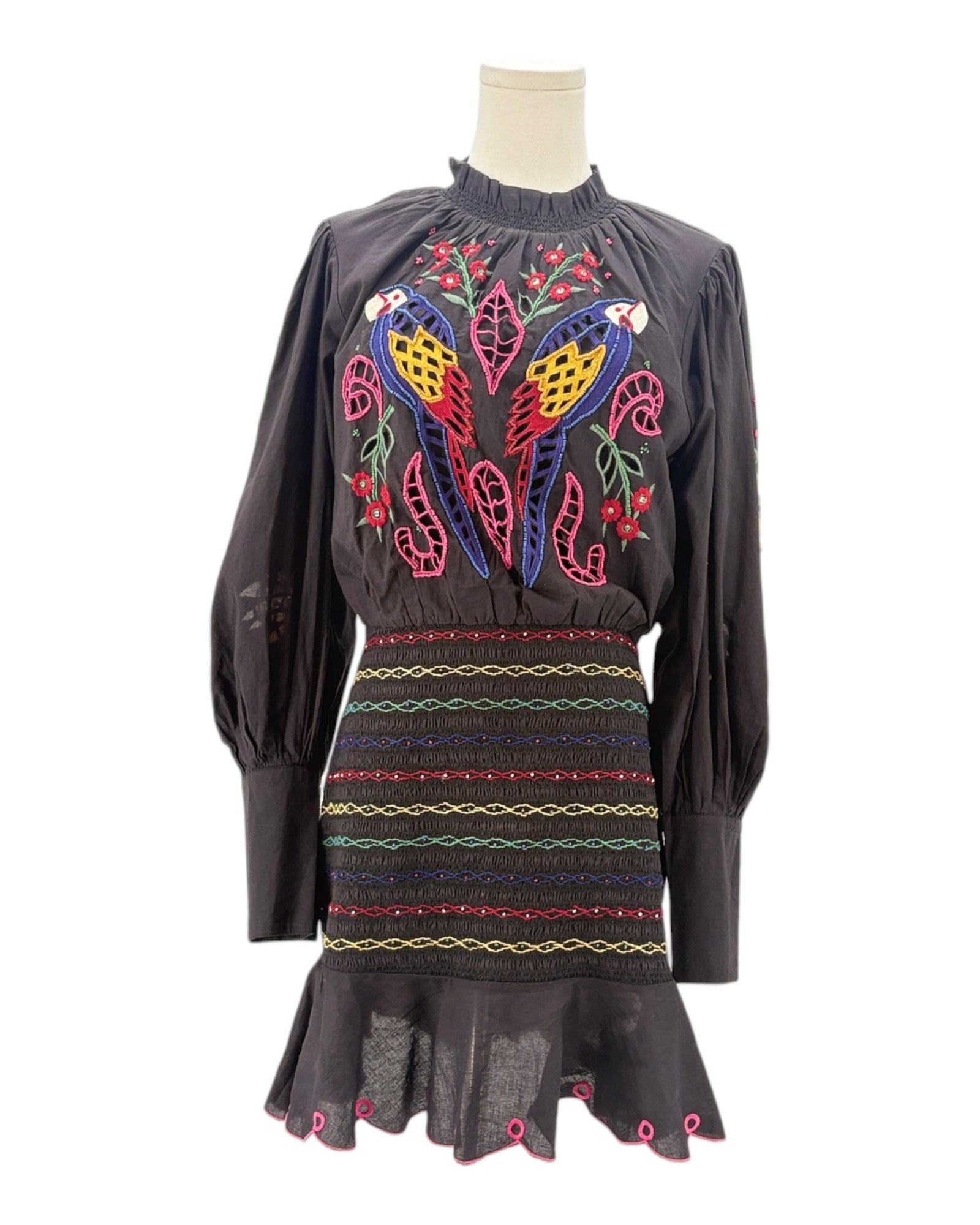 Black dress with colorful parrot embroidery on a mannequin against a white background