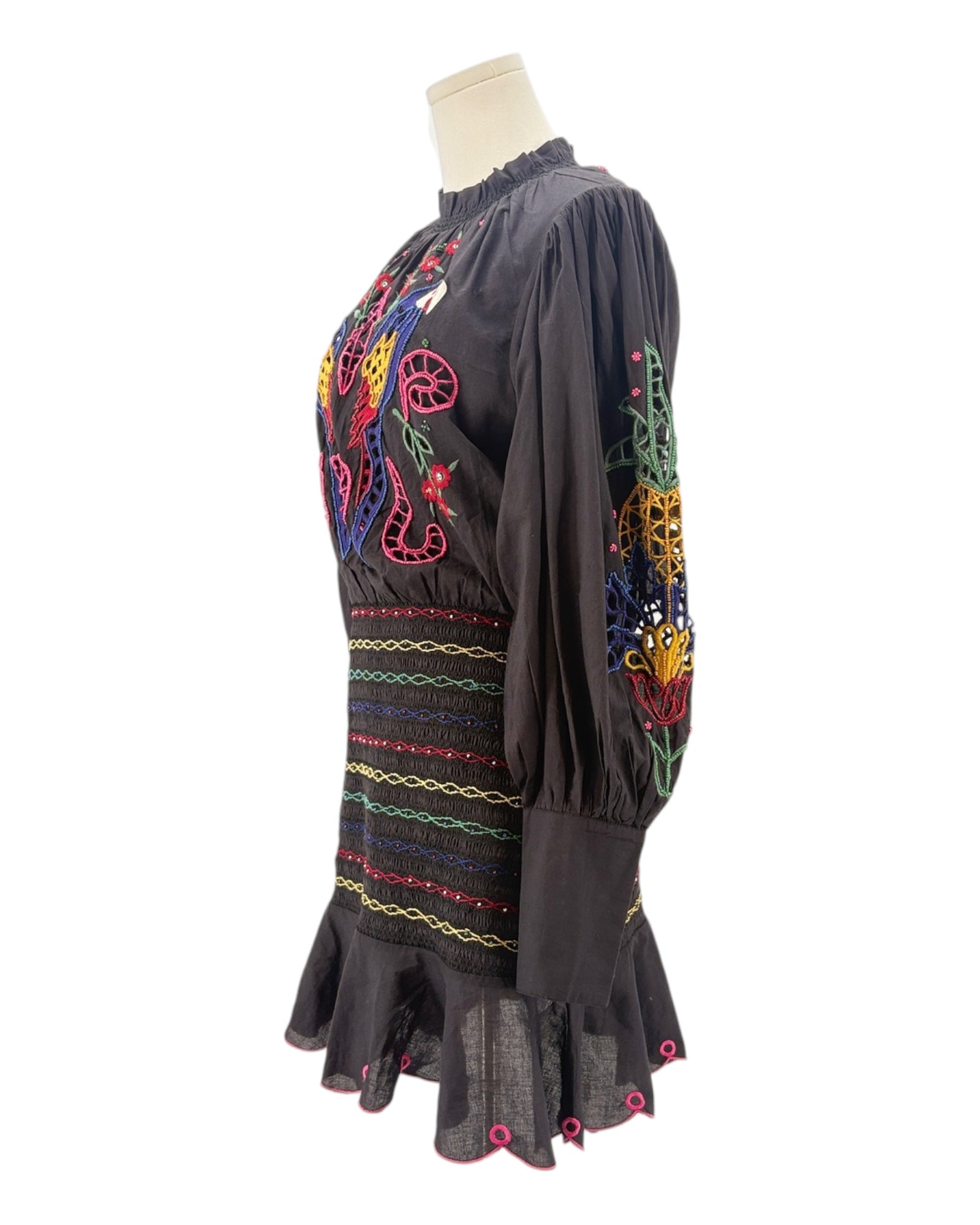 Black dress with colorful embroidery on a mannequin against a white background
