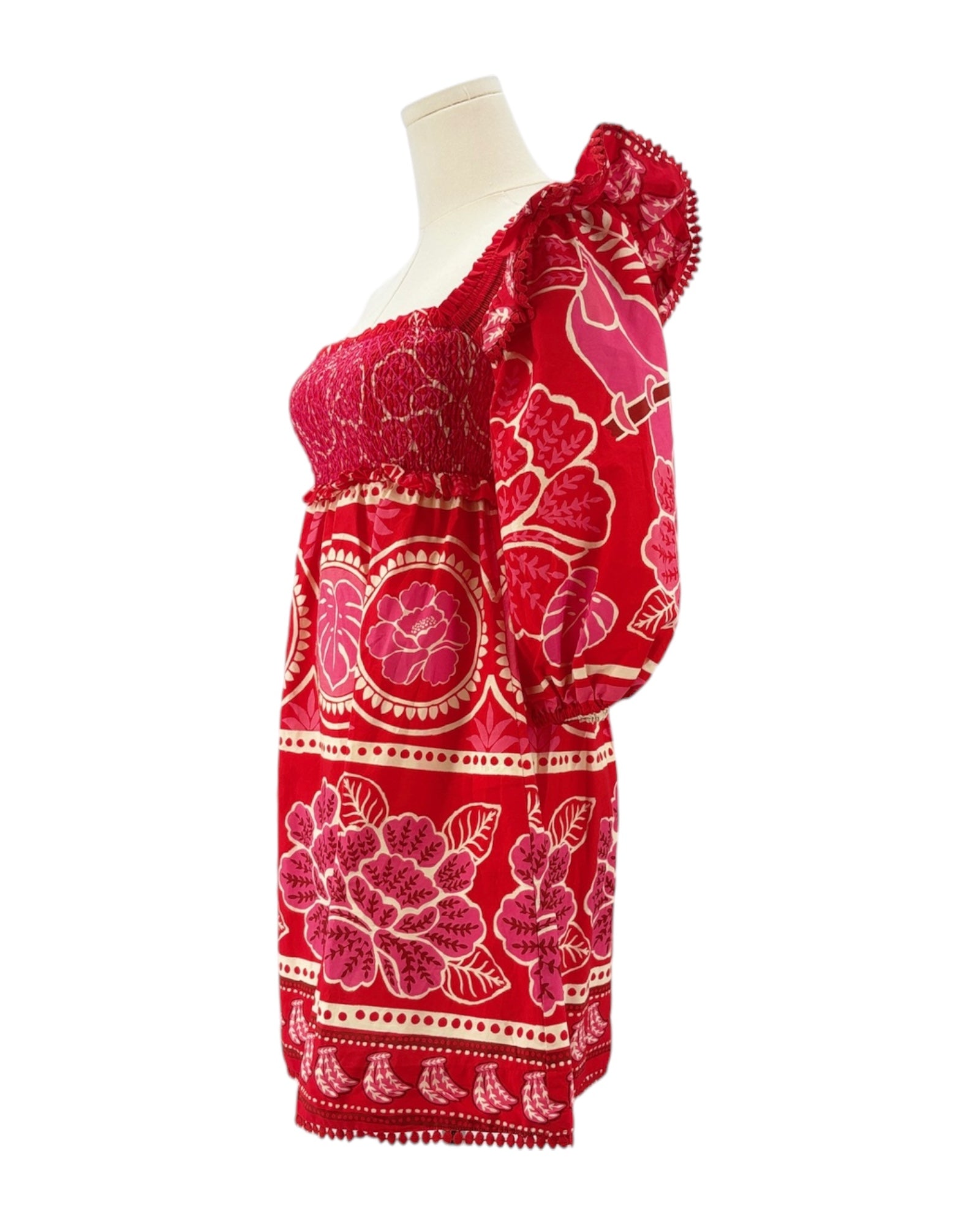 Red patterned dress on a mannequin against a white background