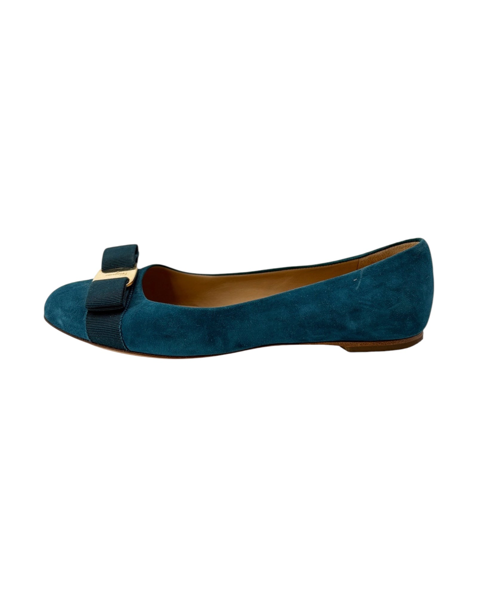 Blue suede flat shoe with a bow on a white background