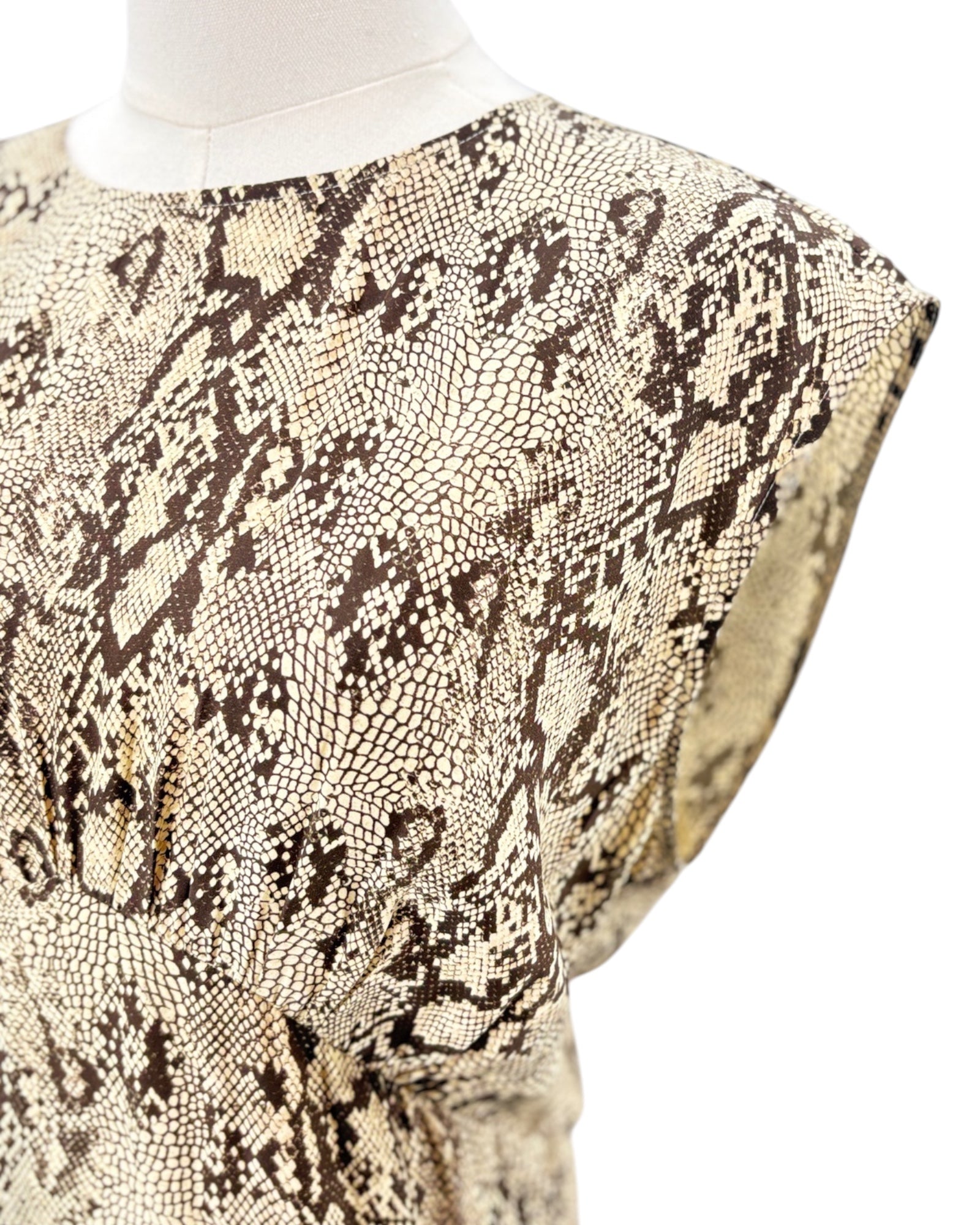Snakeskin patterned dress on a mannequin against a white background