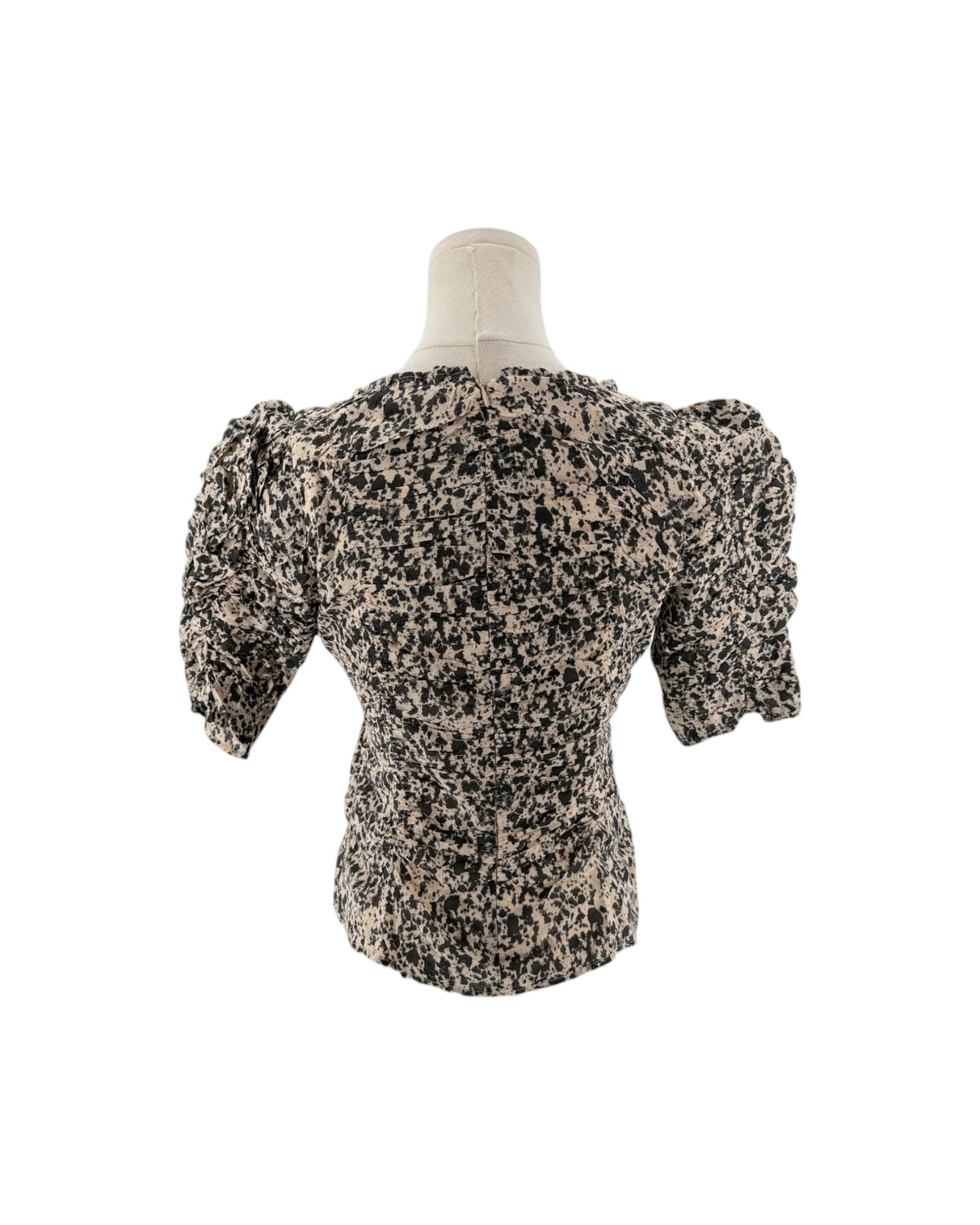 A short-sleeved puff-silhouette blouse with a black and beige speckled pattern, displayed on a mannequin torso against a white background.