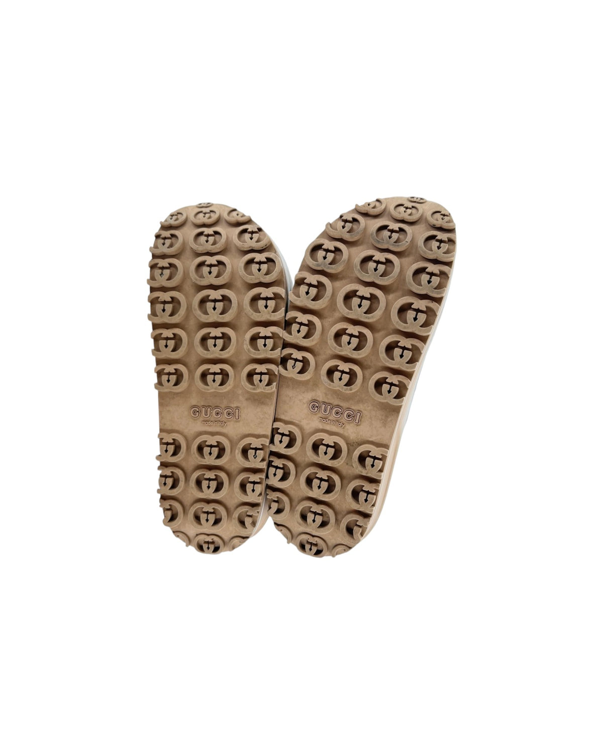 Soles of a pair of Gucci sandals on a white background