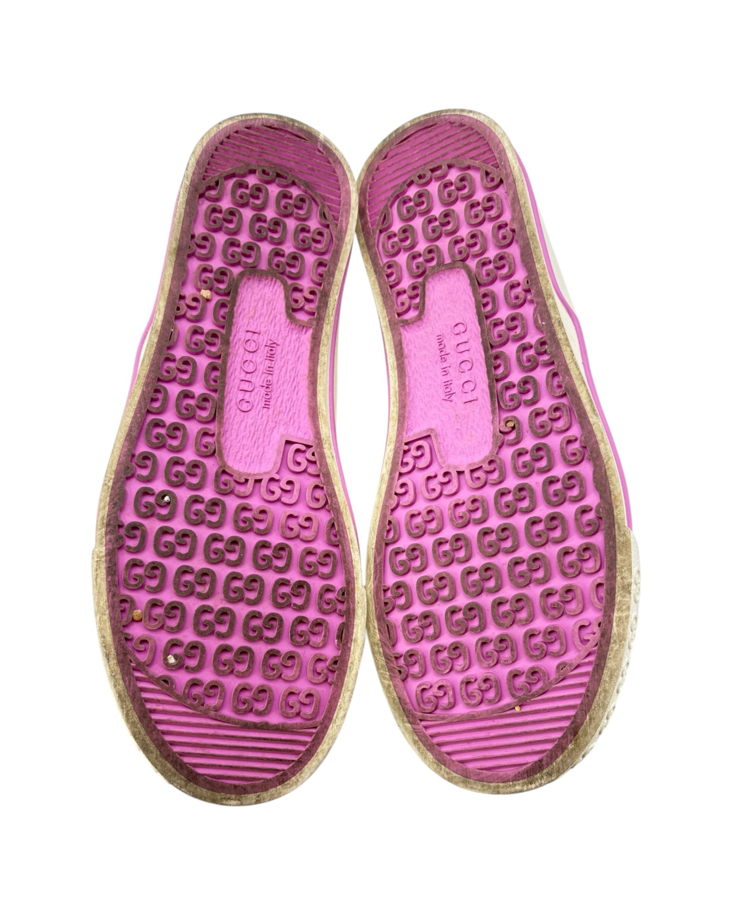 Pink shoe soles with Gucci logo pattern on a white background