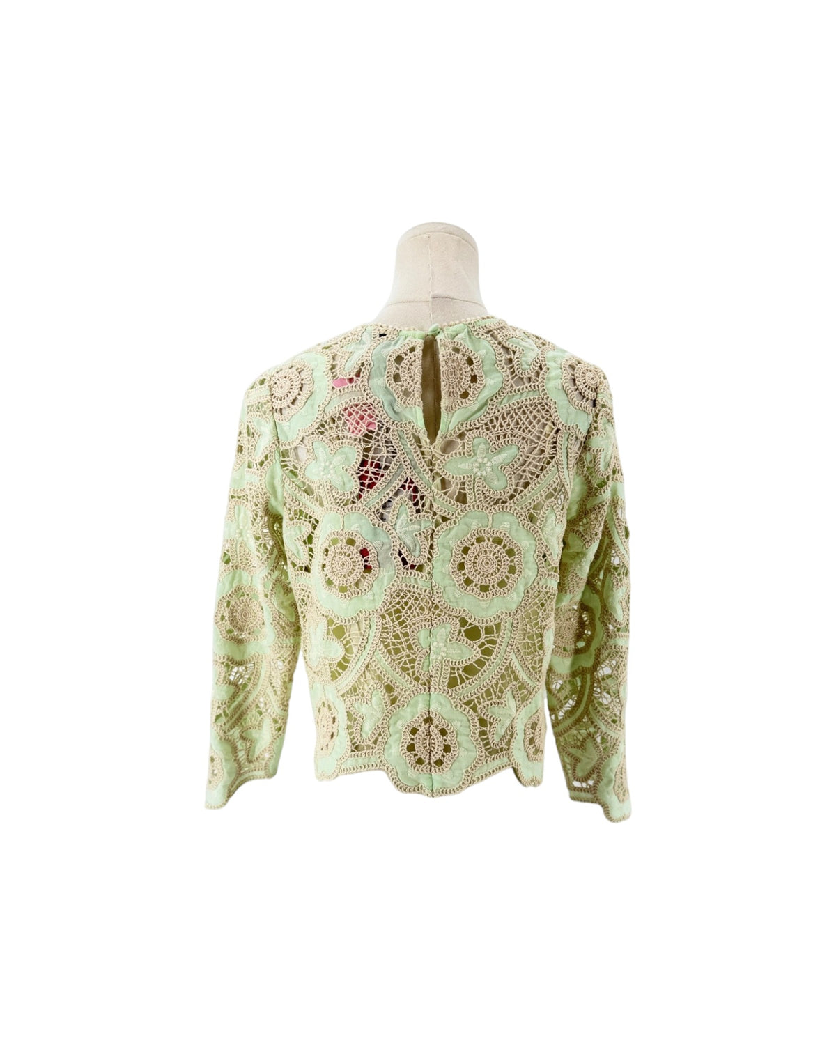 Long sleeve, minty pastel green and off white cream, tactile open-work lace, scalloped edge. On a white background on a mannequin.