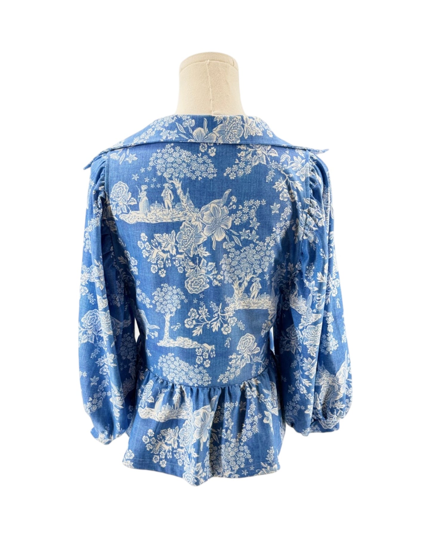 Blue floral patterned blouse on a mannequin against a white background