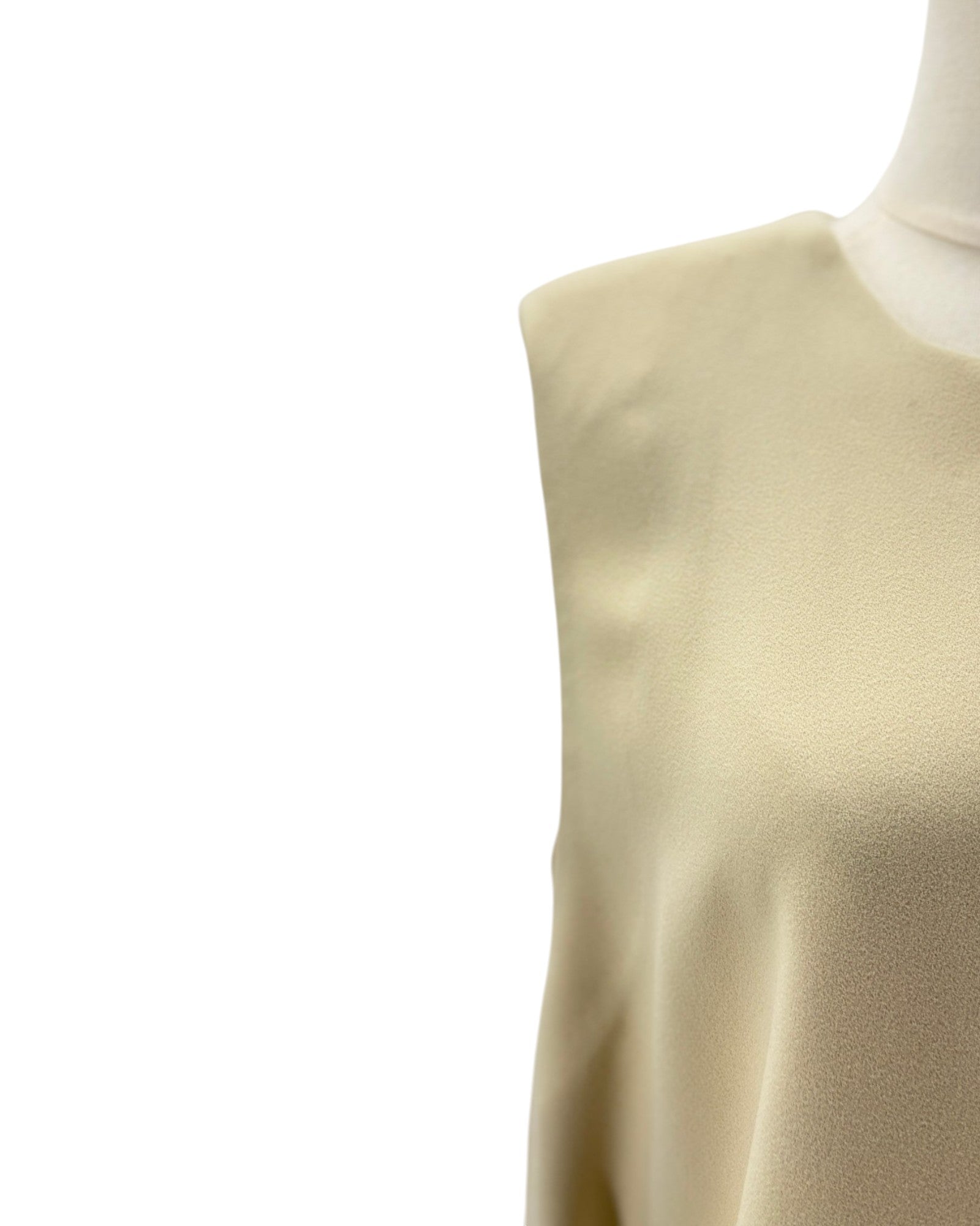Beige sleeveless top on a mannequin against a white background