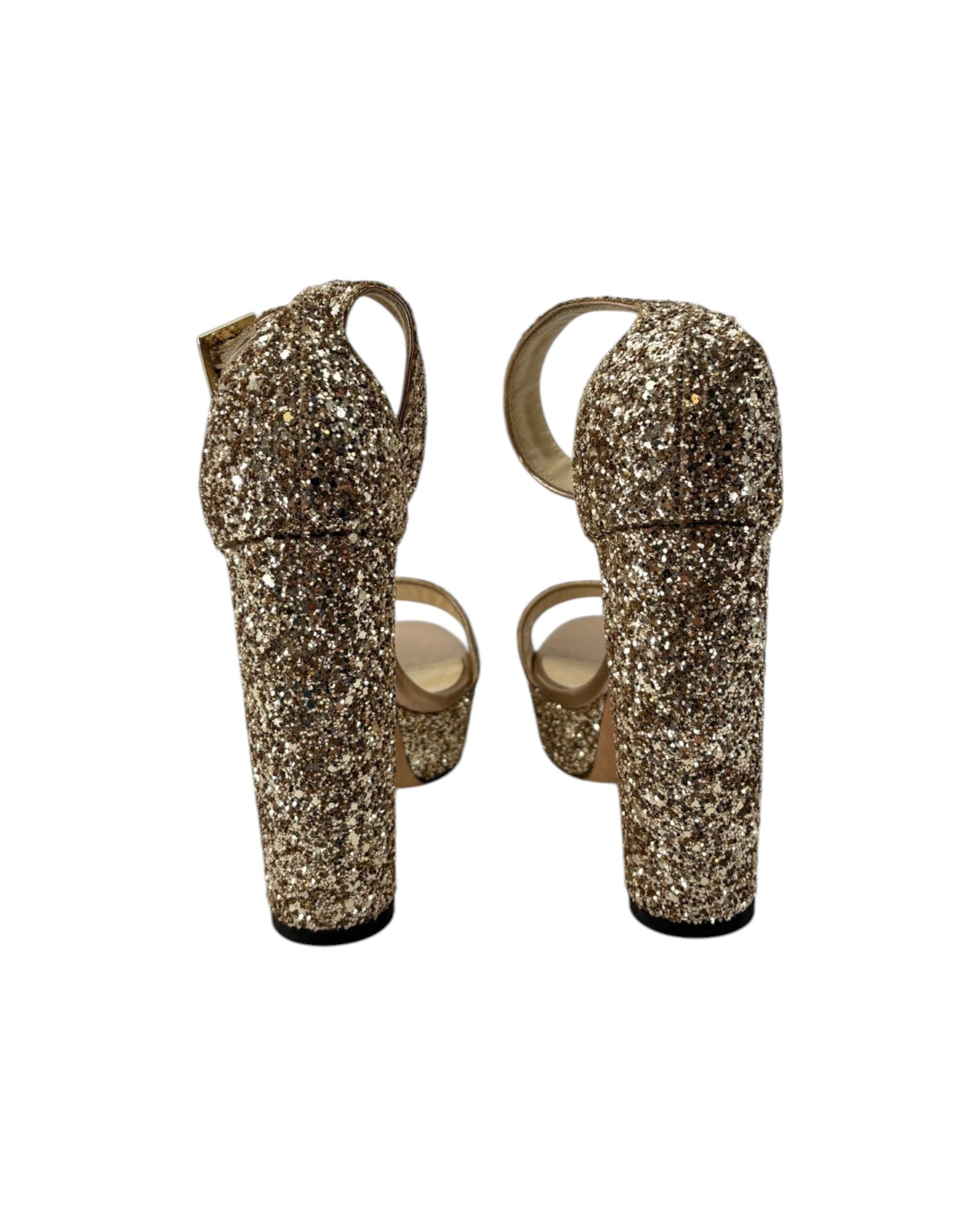 Gold glittery high-heeled shoes on a white background