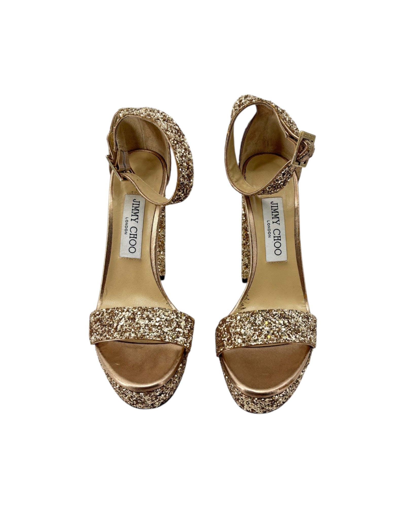 Gold glitter high-heeled shoes with Jimmy Choo label on a white background
