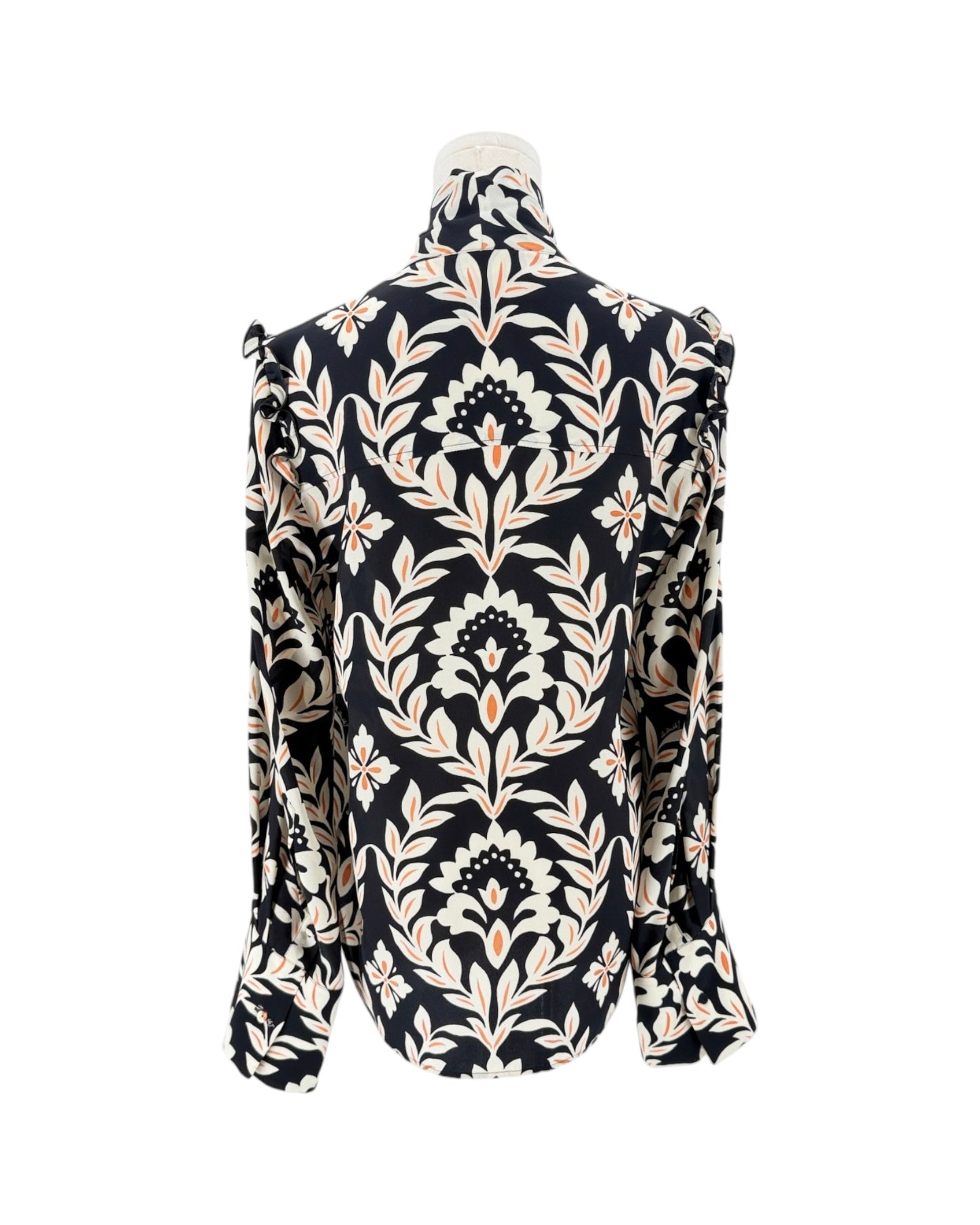 A long-sleeve high-neck blouse with a dramatic ruffled collar and shoulders, featuring an intricate black, beige, and white damask floral pattern, displayed on a mannequin against a white background.