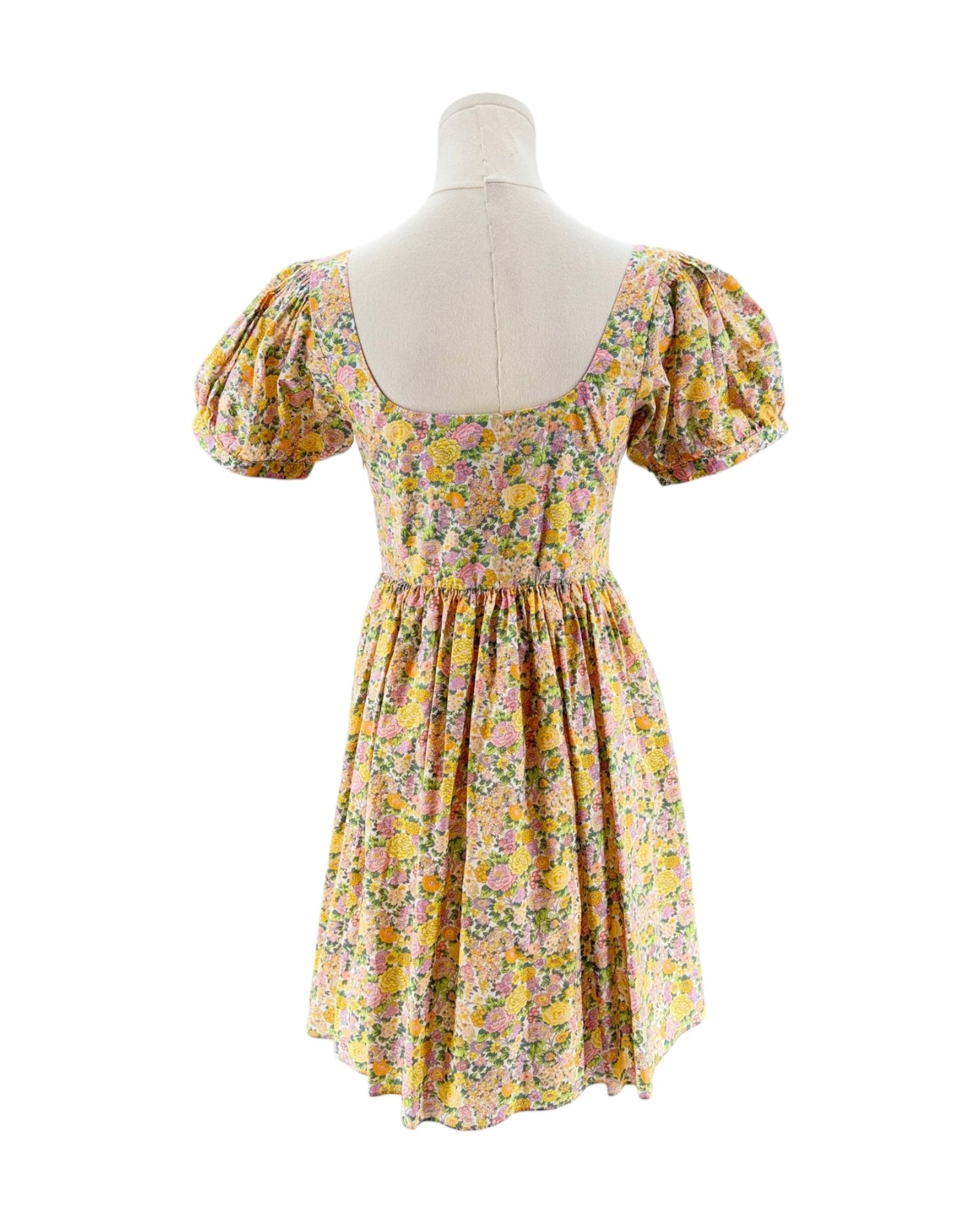 Floral dress on a mannequin against a white background
