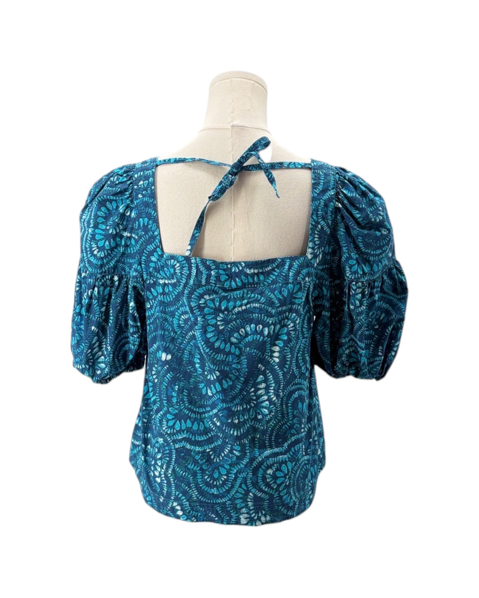 Blue patterned blouse on a mannequin with a white background