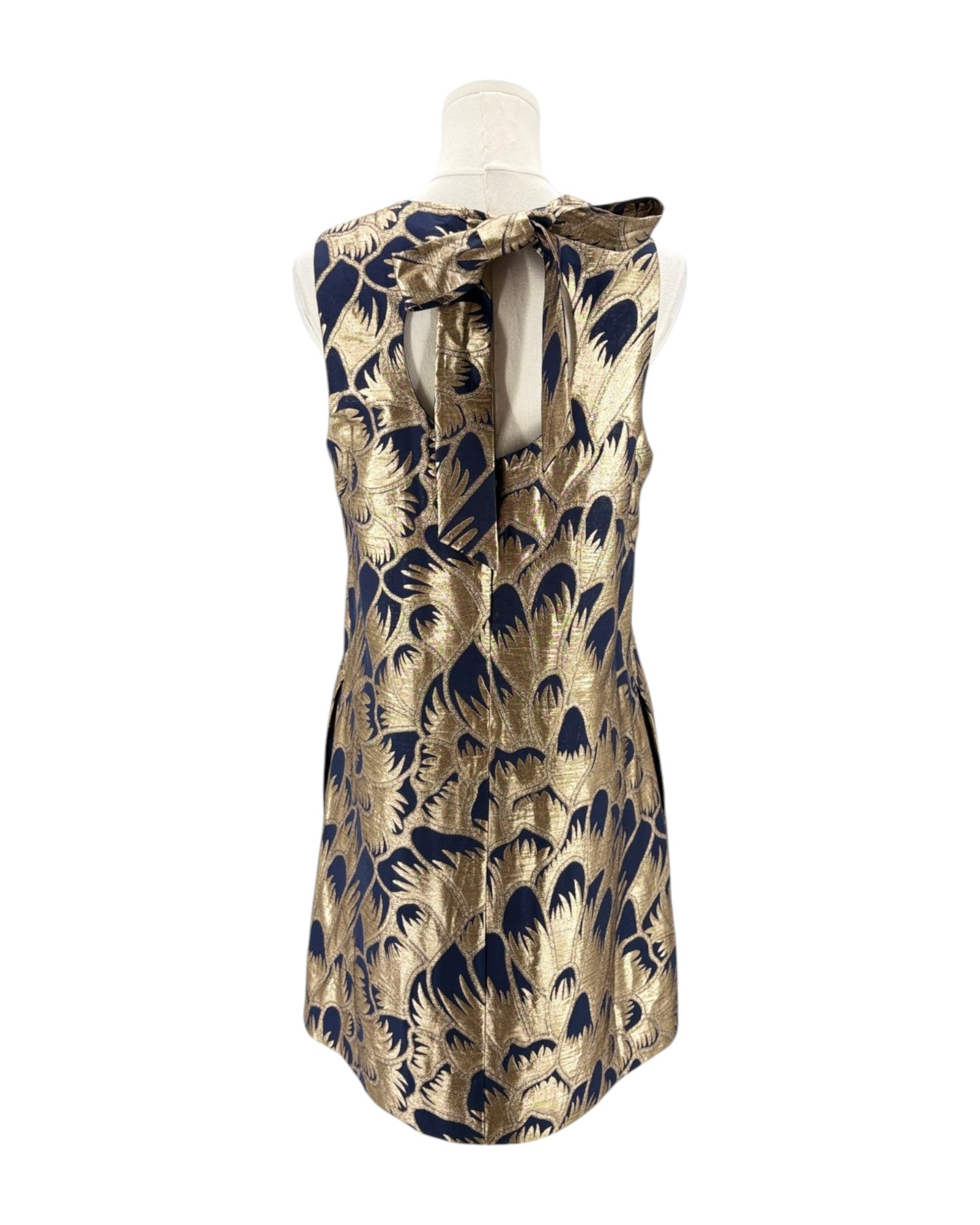 Gold and navy patterned dress on a mannequin against a white background