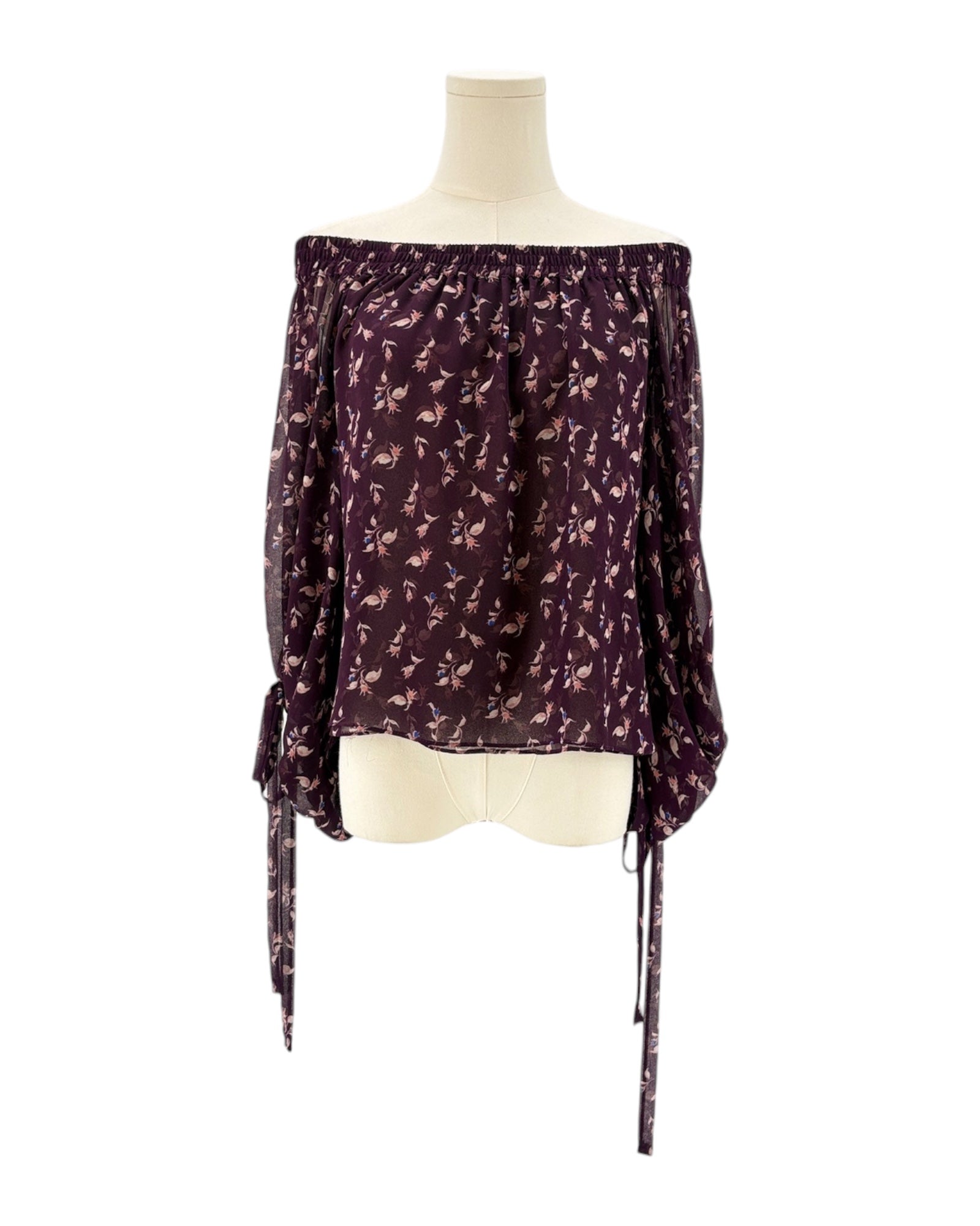 Purple off-shoulder top with floral pattern on a mannequin against a white background