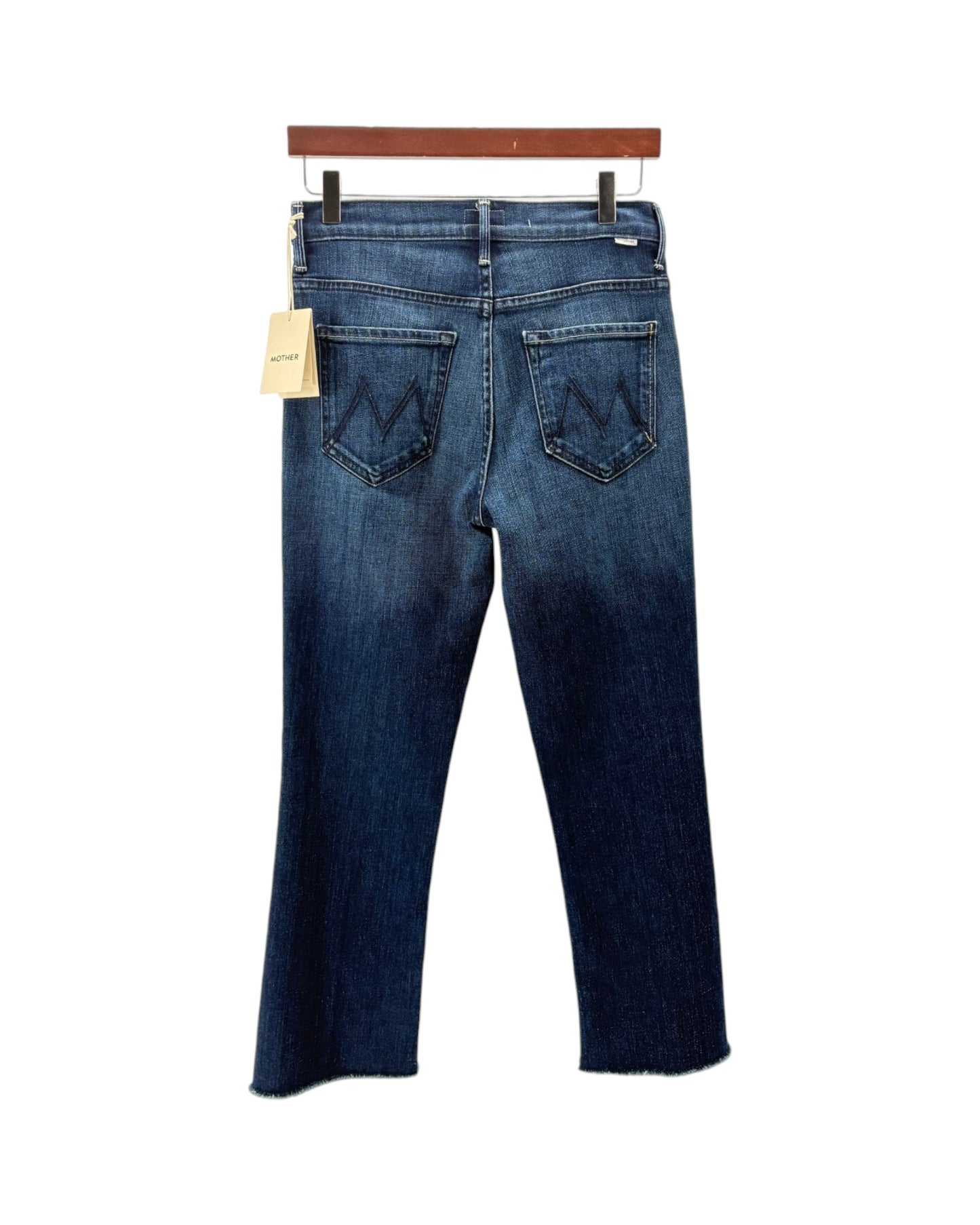 Back view of a pair of dark blue denim jeans hanging on a wooden hanger against a white background, featuring a paper tag and the signature W logo on the back pockets.