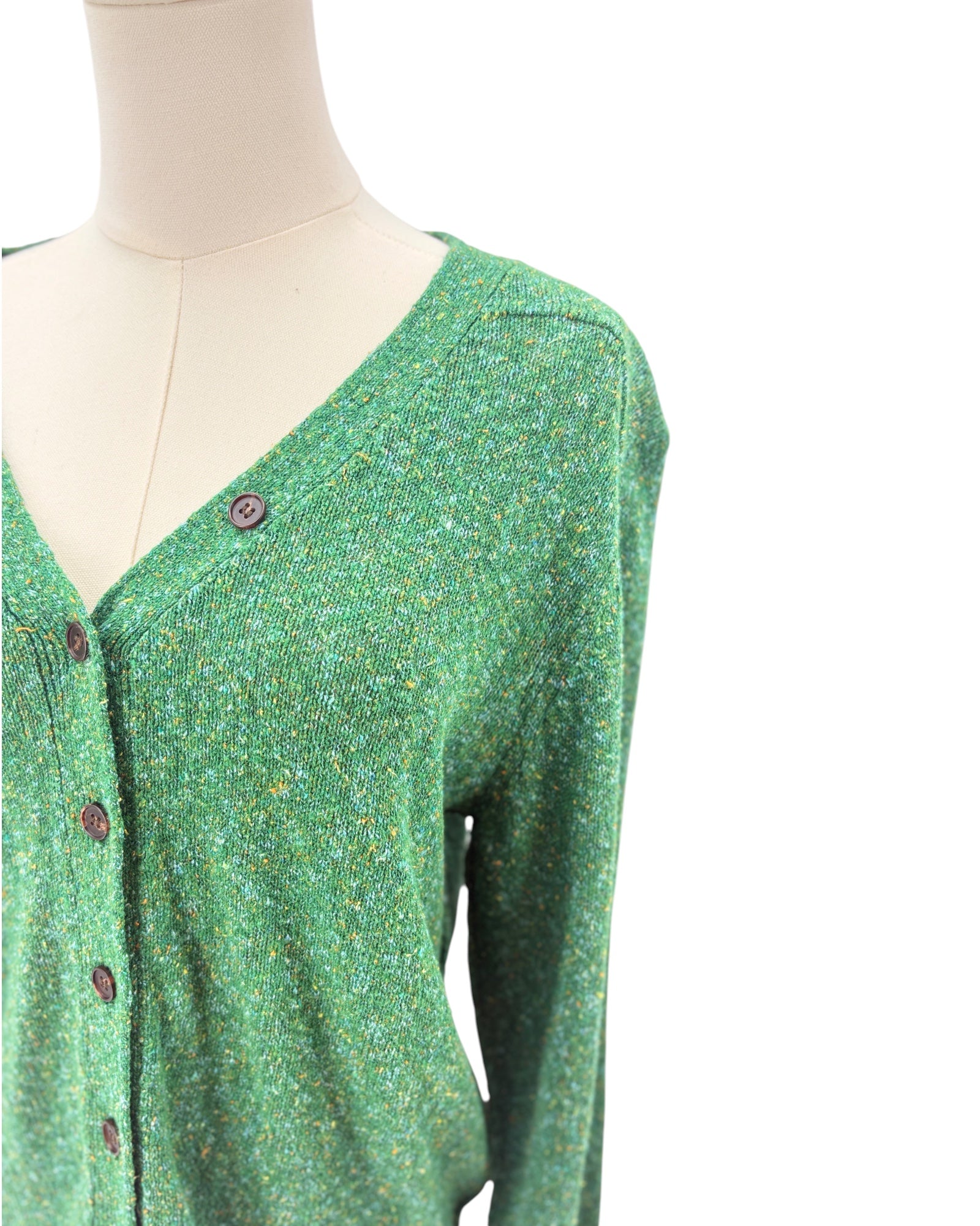 Green cardigan sweater on a mannequin against a white background