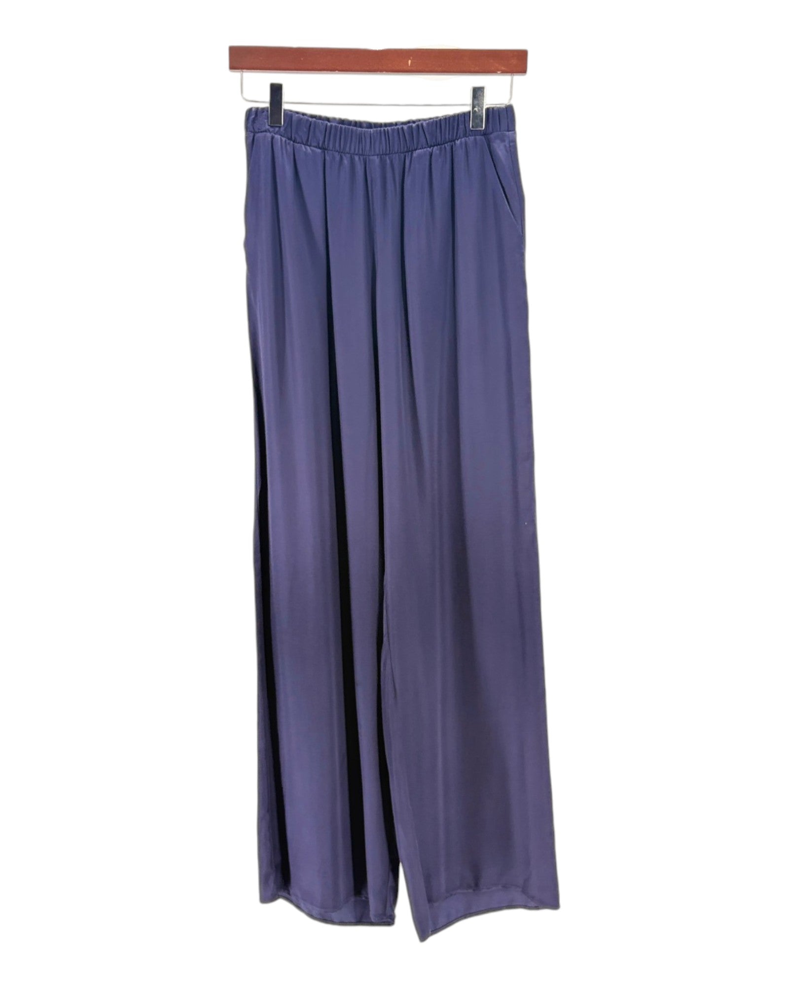Navy wide-leg pants hanging on a wooden hanger against a white background