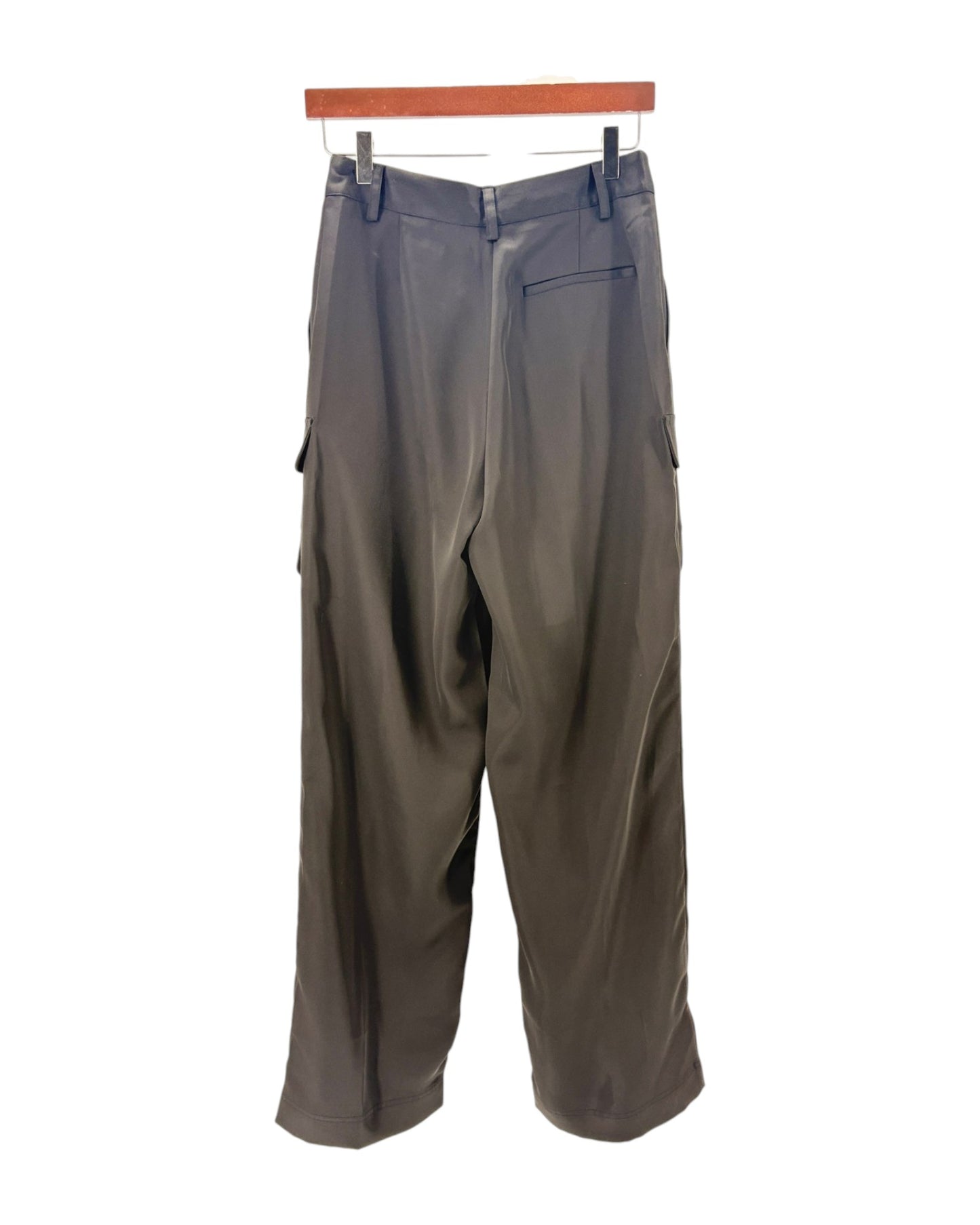 black pants hanging on a wooden rack against a white background