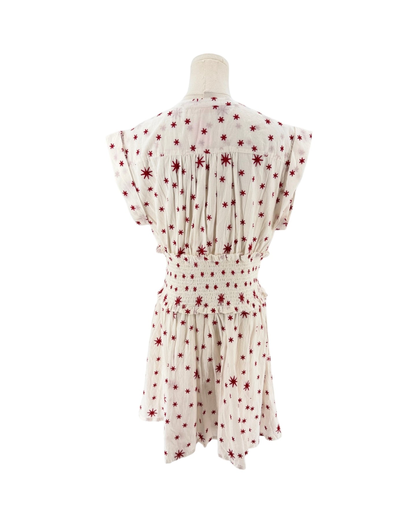 A cream-colored short-sleeve dress with a red starburst pattern, shown from the back on a mannequin against a white background.