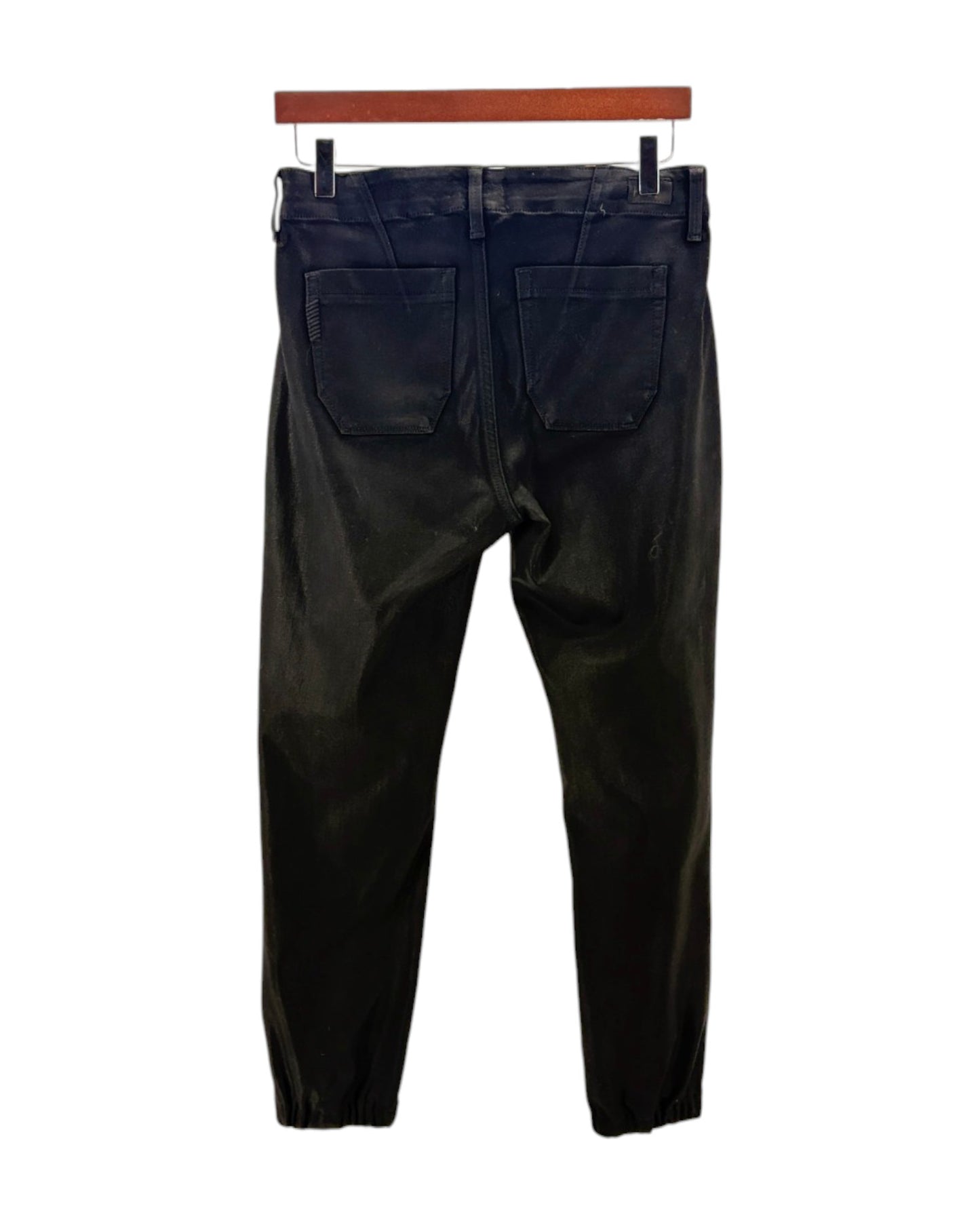 Black coated pants on a hanger against a white background
