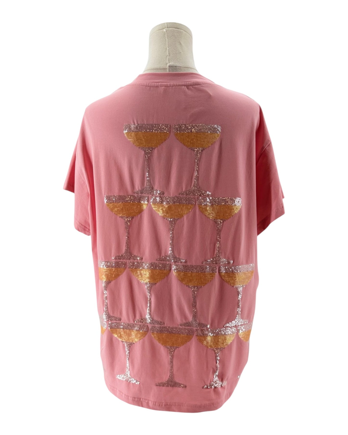 Pink t-shirt with wine glass pattern on a mannequin against a white background