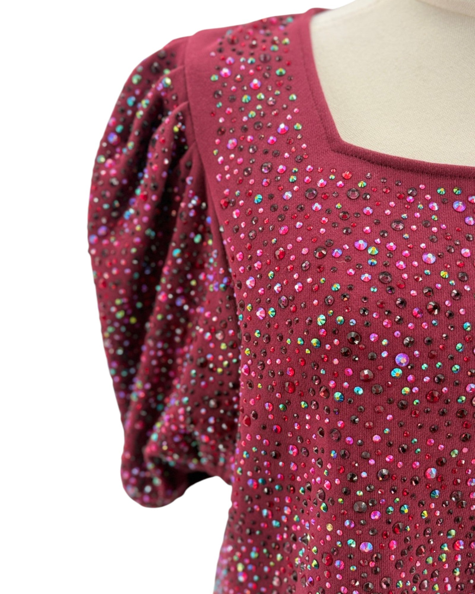 Red top with multicolored embellishments on a white background