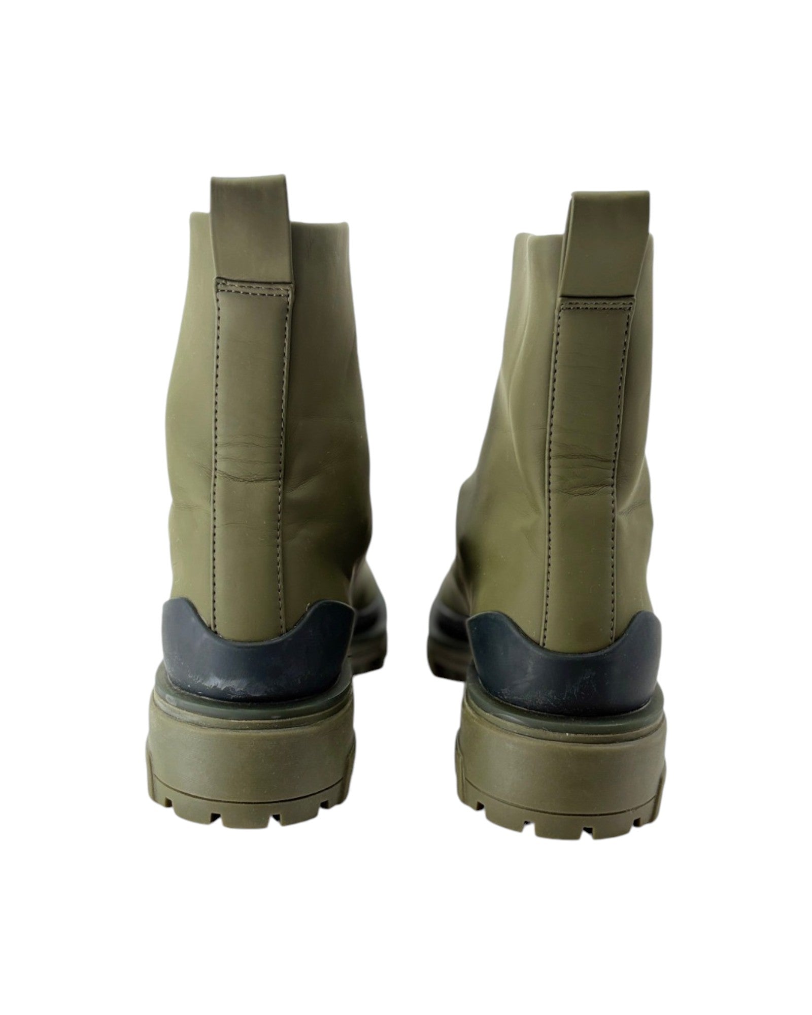 Pair of green boots with black soles on a white background
