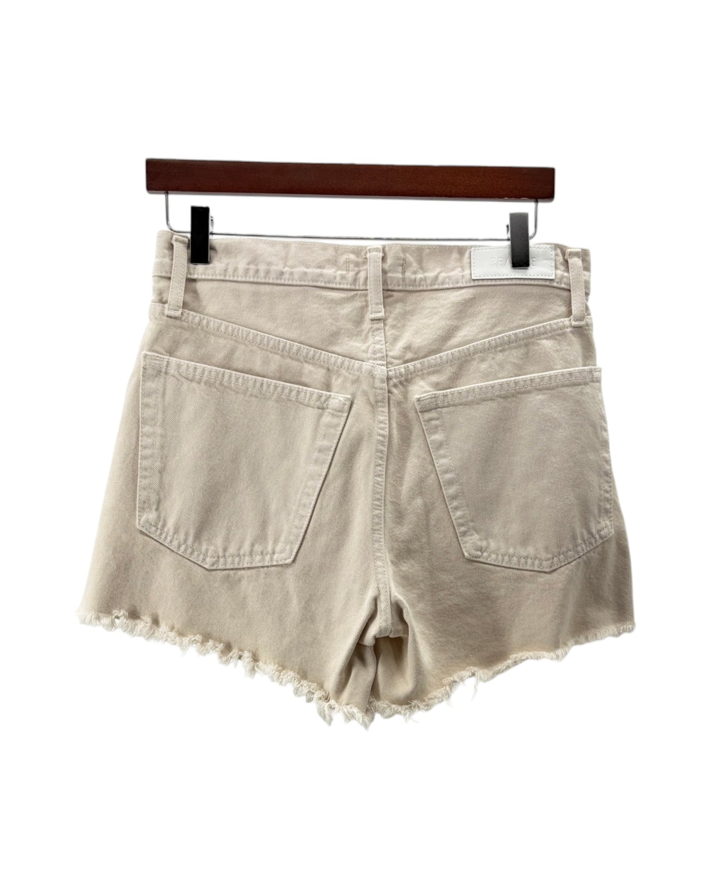 Beige denim shorts on a hanger against a white background
