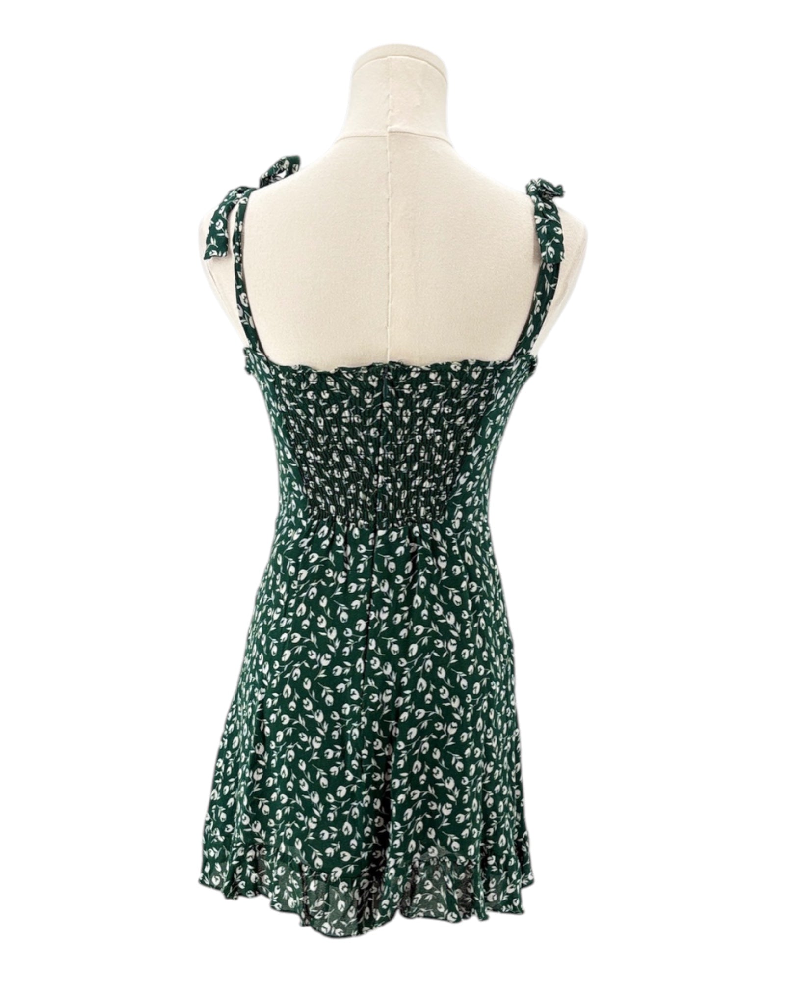 Green floral dress on a mannequin against a white background