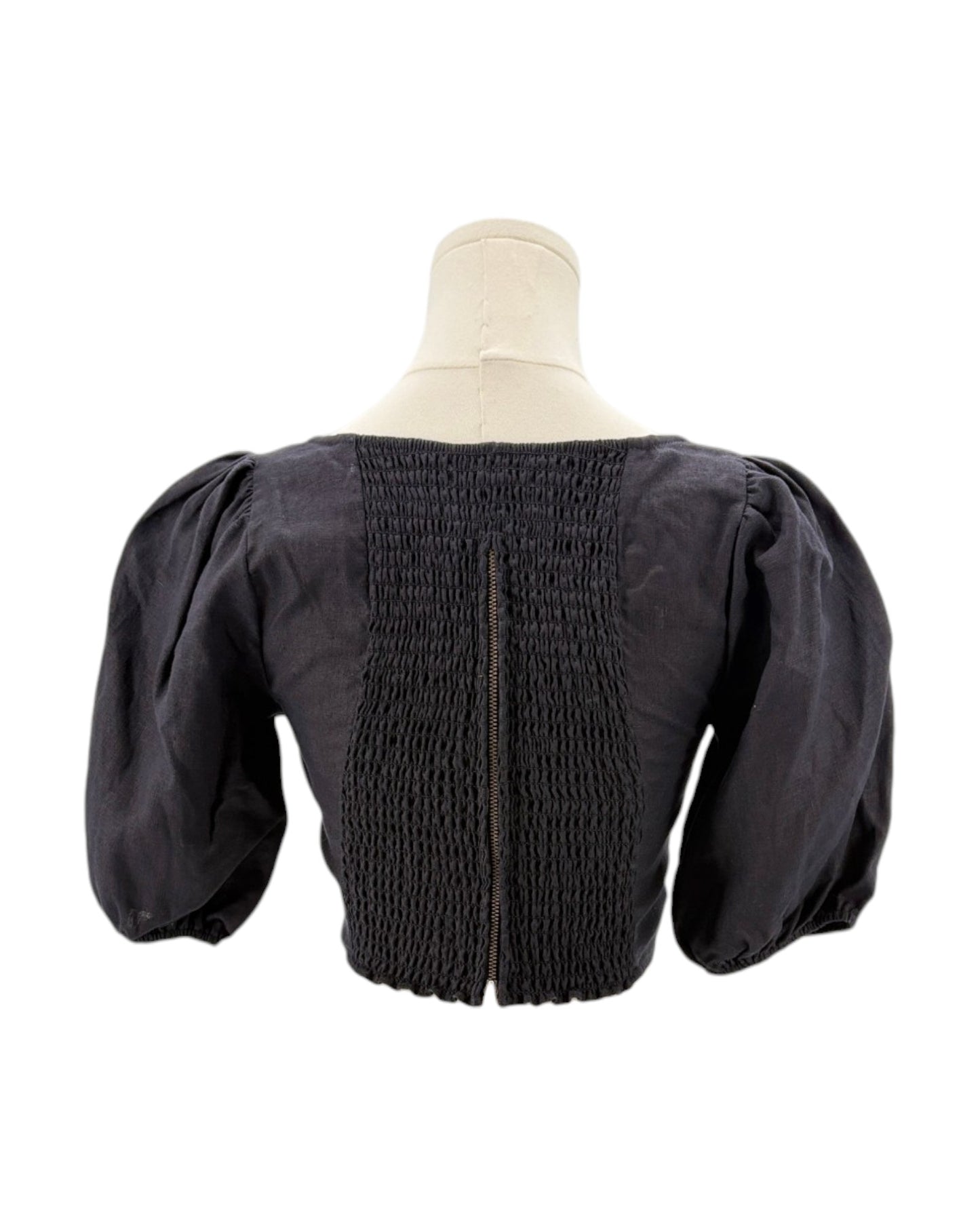 Reformation black blouse with puffed sleeves on a mannequin against a white background
