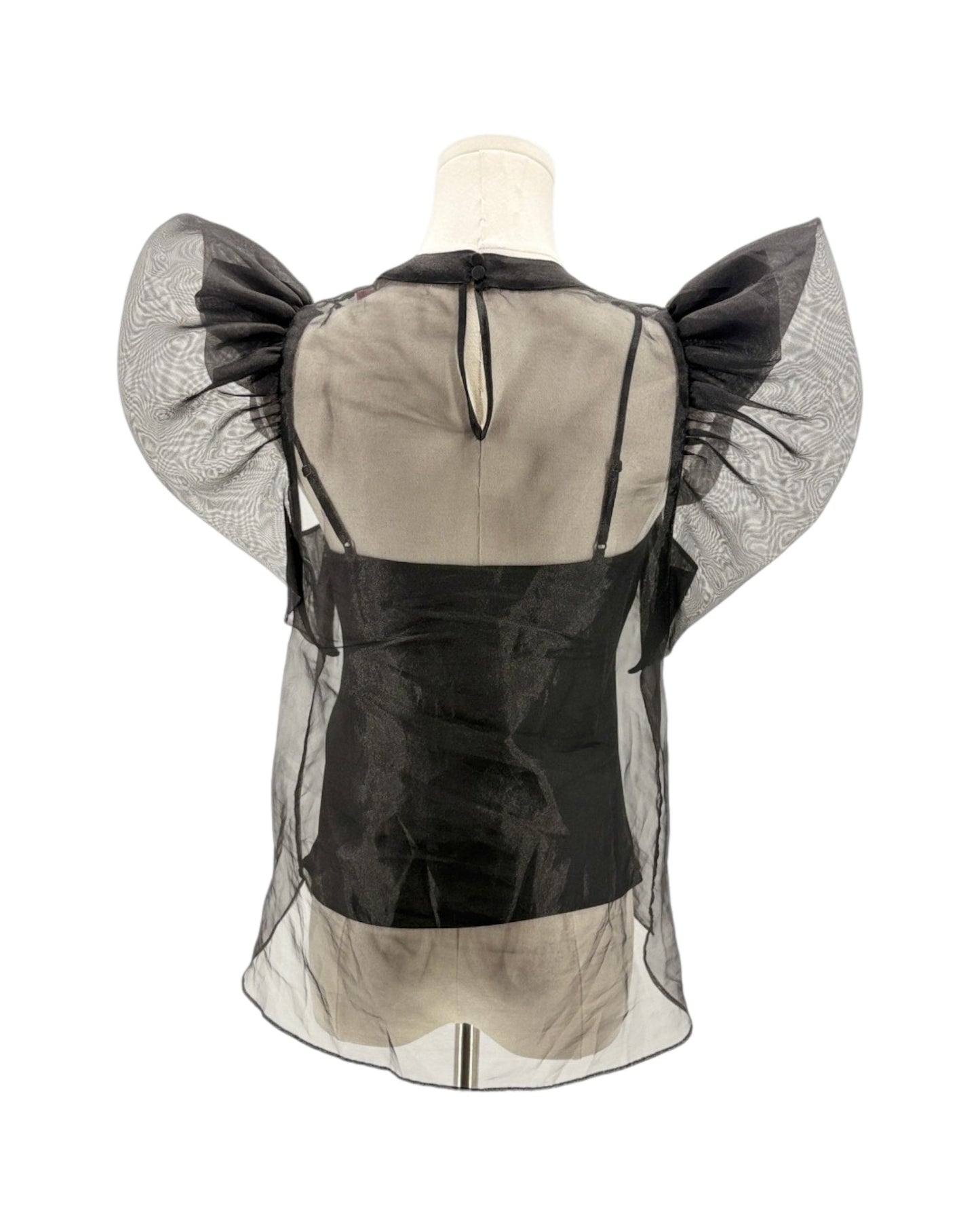 Mannequin wearing a black and beige outfit with sheer sleeves on a white background