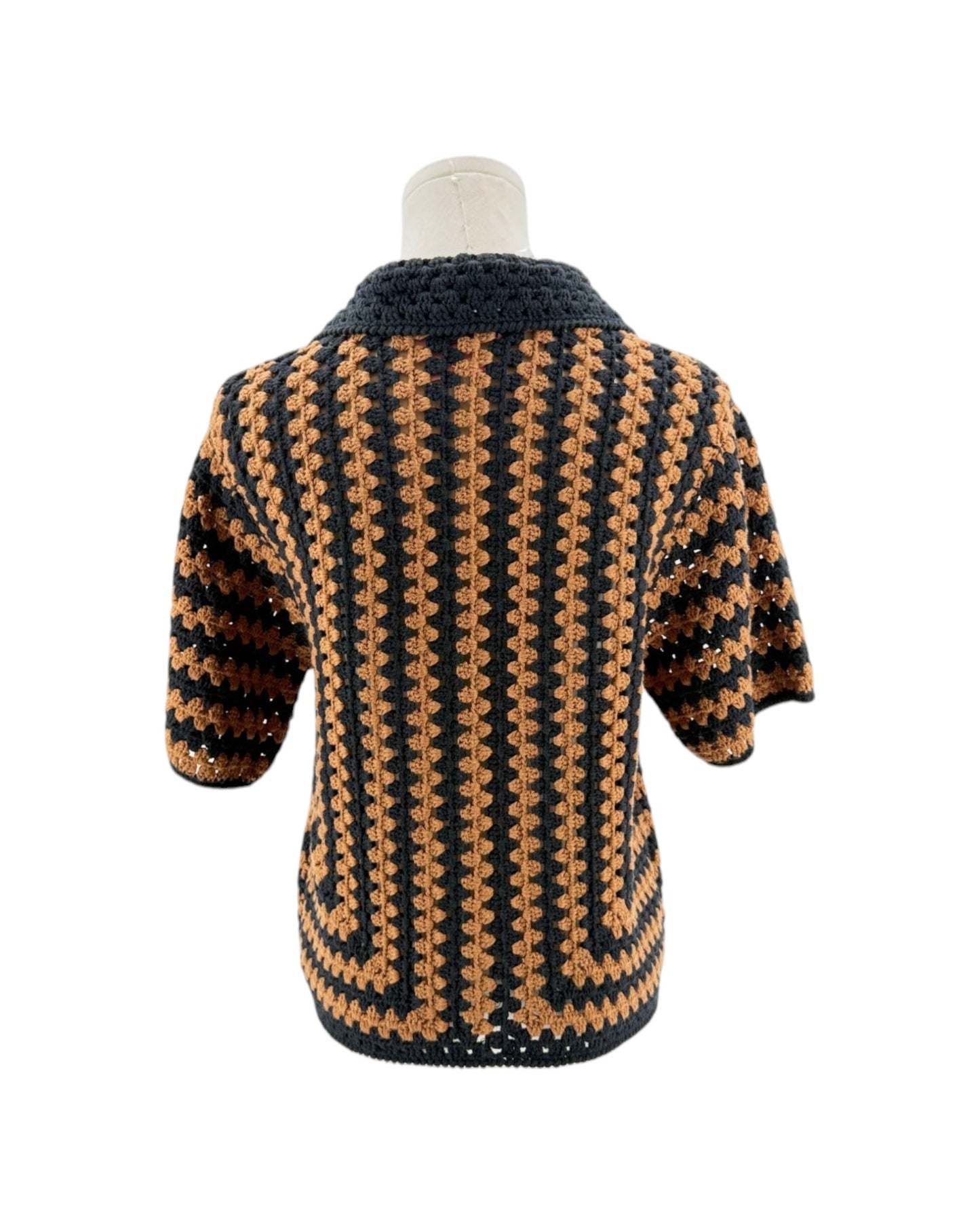Mannequin wearing a black and brown patterned sweater on a white background