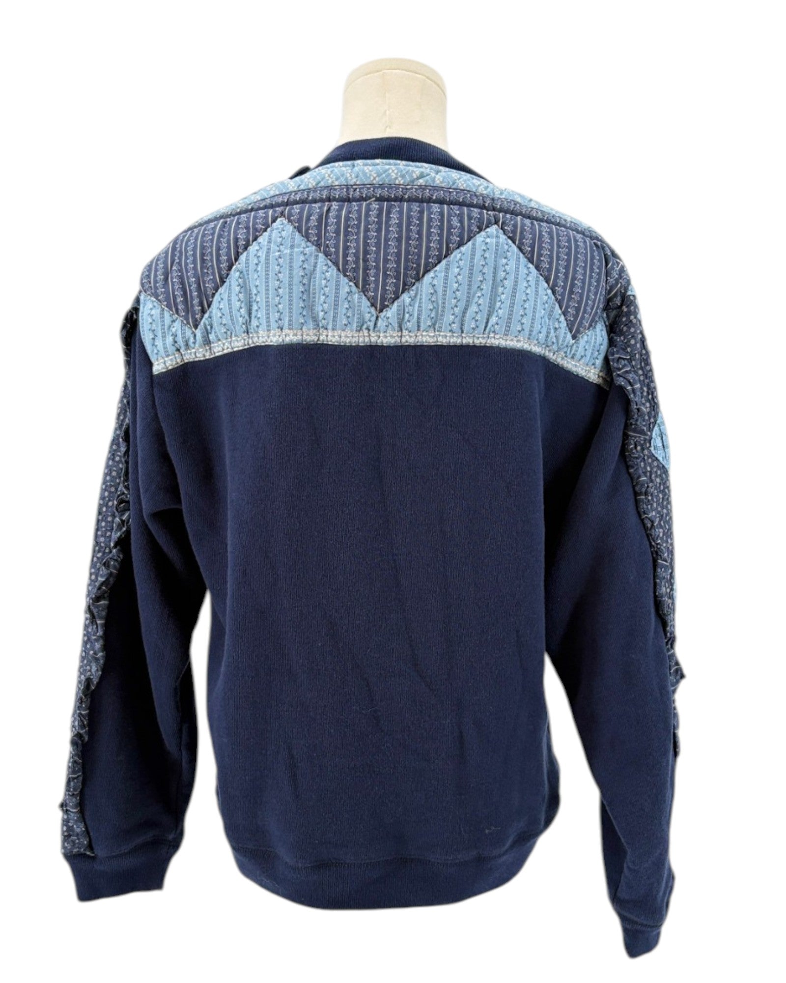Sea NY navy blue sweater with a patchwork pattern on a mannequin against a white background