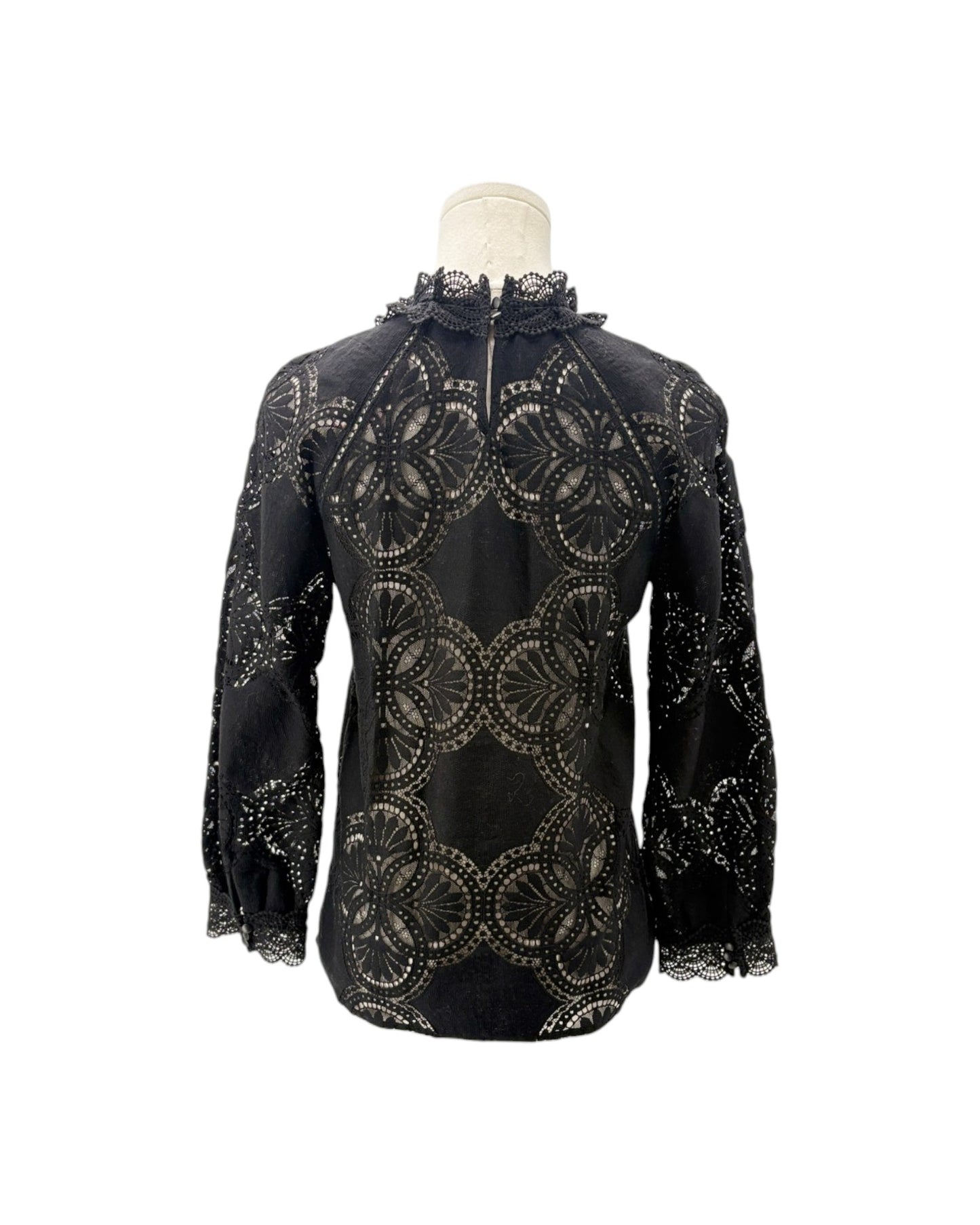 A black long-sleeve blouse with an intricate circular lace cutout pattern, displayed on a mannequin torso against a plain white background.